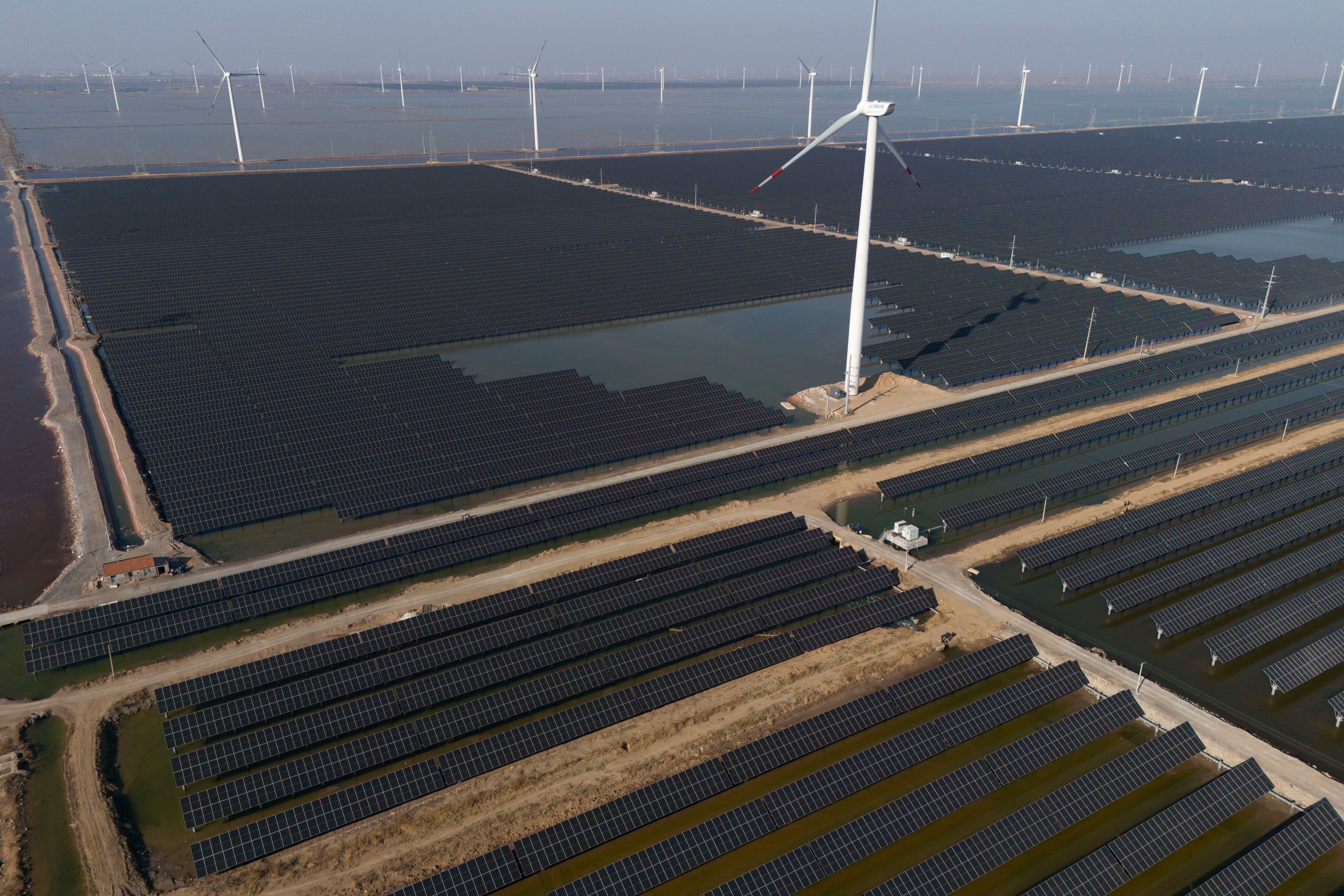 FILE - Wind turbines dot the coast line along a giant solar farm near Weifang in eastern China's Shandong province on March 22, 2024. (AP Photo/Ng Han Guan, File)