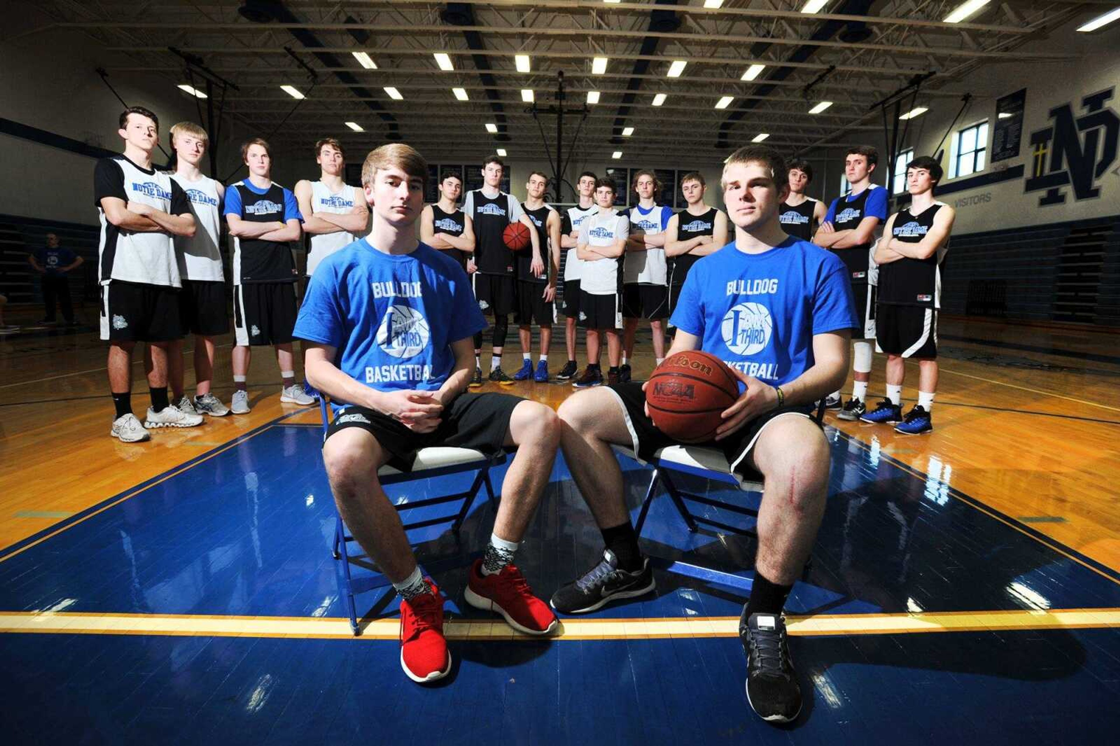 Notre Dame seniors Grant Ressel, left, and Derek Hulshof sit surrounded by their teammates Monday at Notre Dame High School. Both players suffered torn ACLs this season, which has given way for several other players to step in and contribute for the Bulldogs. (Laura Simon)