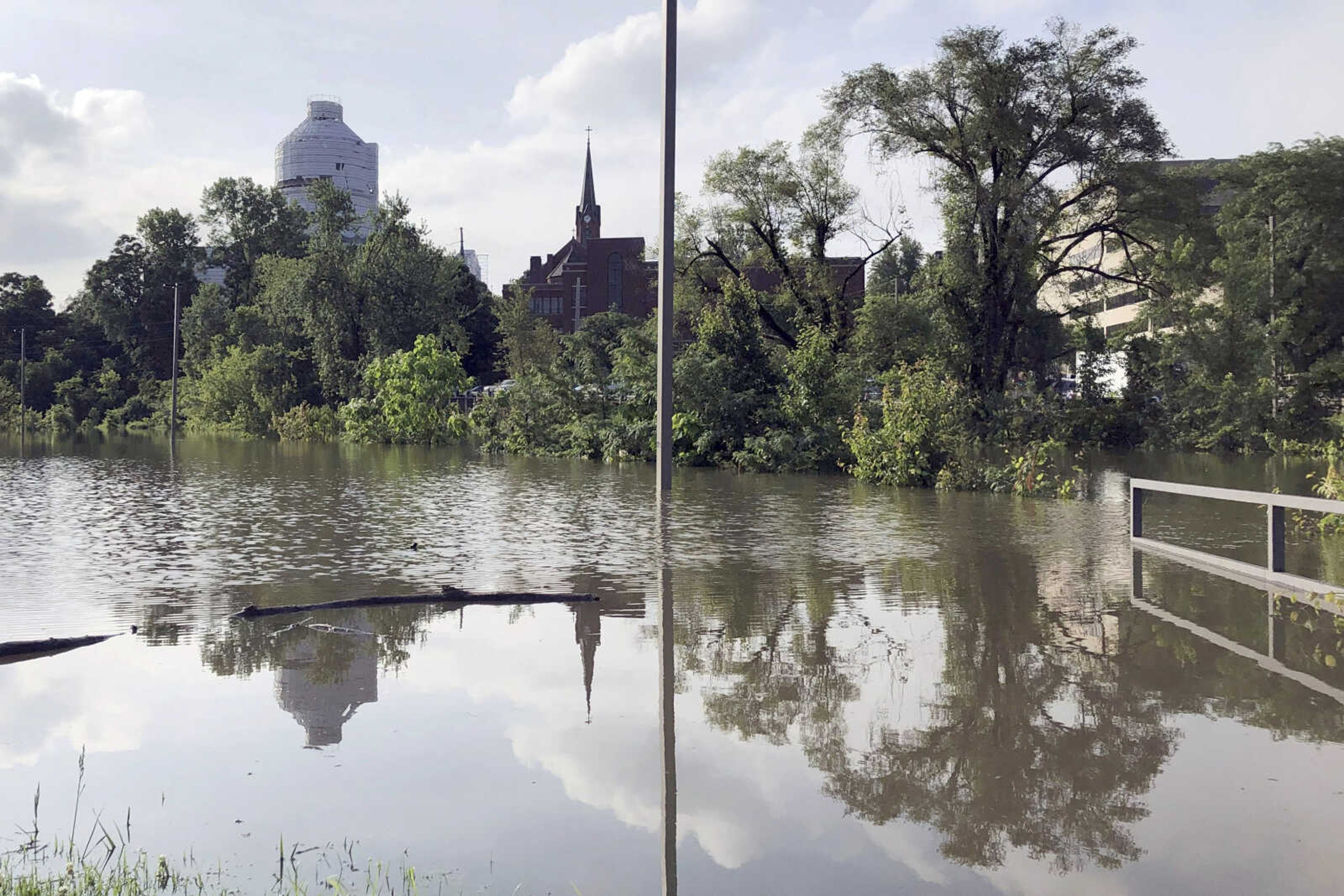 The Missouri Capitol, which is wrapped in plastic while under renovation, is reflected in floodwaters that submerged a parking lot for state employees in Jefferson City, Missouri, on May 29. For years, states have relied heavily on the Federal Emergency Management Agency to pay the bulk of recovery efforts for damaged public infrastructure. While that remains the case, more states have been debating ways to supplement federal dollars with their own money dedicated not just to rebuilding but also to avoiding future flood damage.