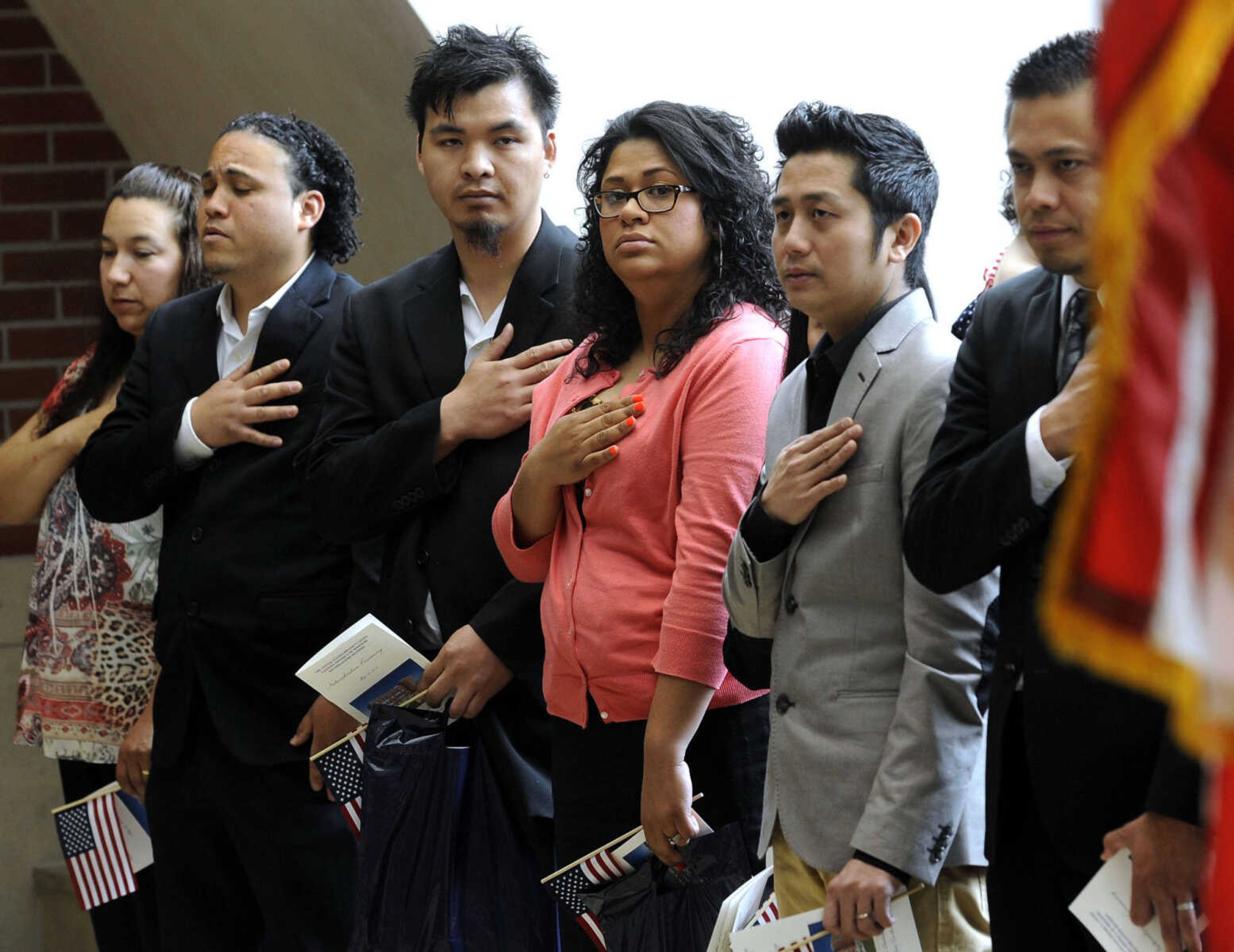 The petitioners stand for the National Anthem during a naturalization ceremony Friday, May 2, 2014 at the Rush H. Limbaugh Sr. U.S. Courthouse in Cape Girardeau.