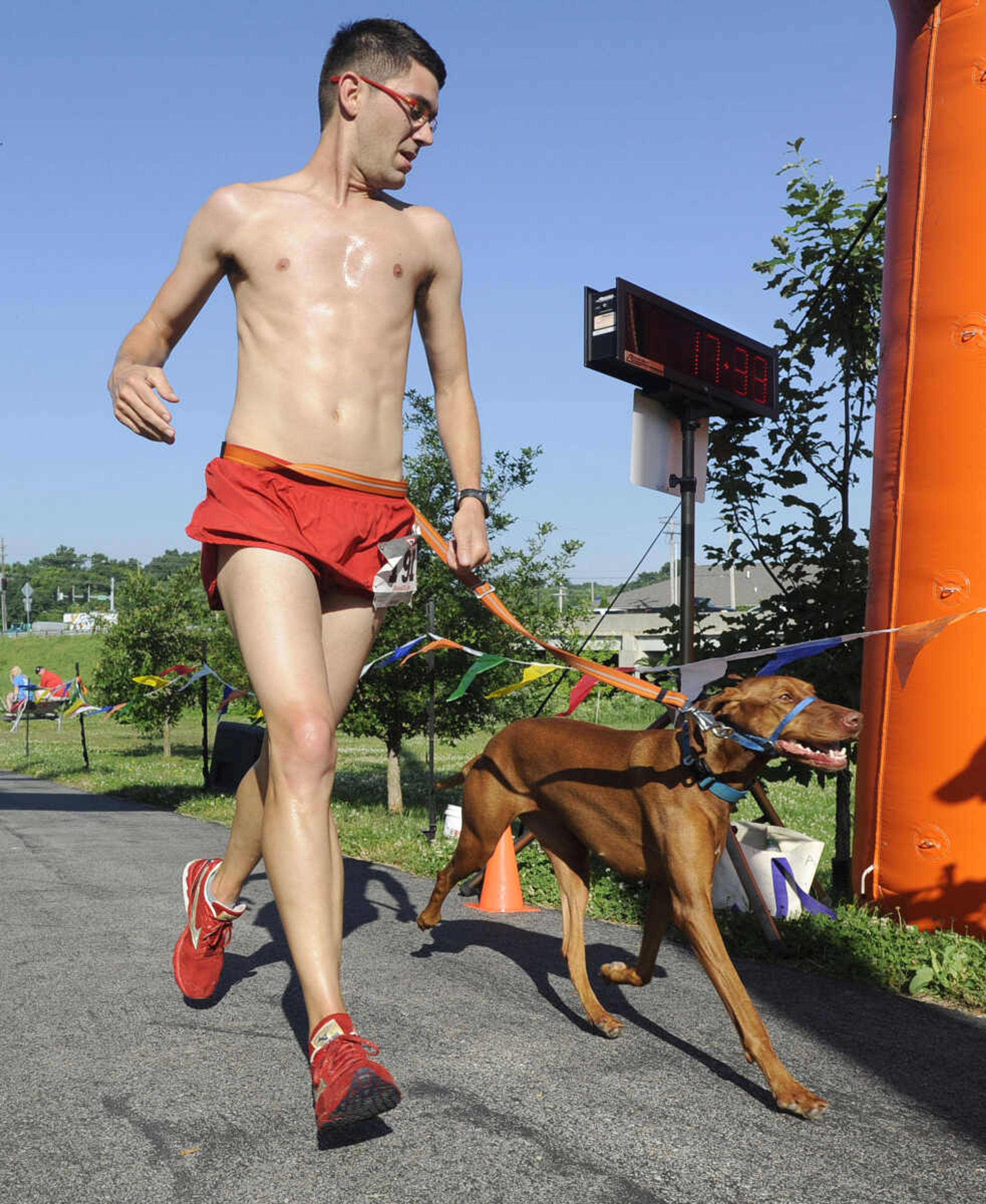 Ryan Lane finishes first with a friend's dog, Zoey, in the Furry 5K and one-mile Fun Walk Saturday, June 6, 2015 in Cape Girardeau.