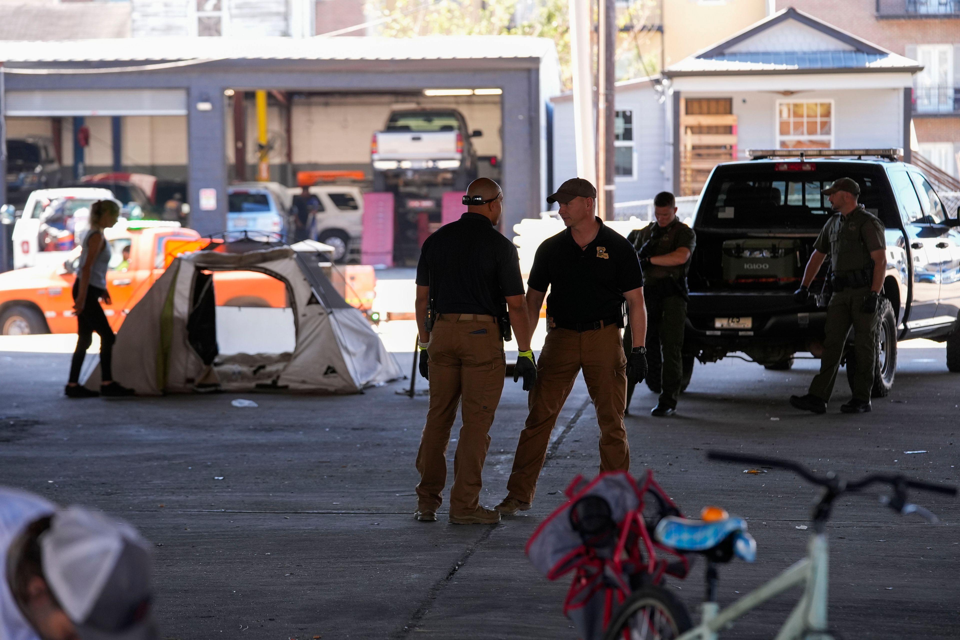 Louisiana State police give instructions to people living in a homeless encampment to move to a different pre-designated location as they perform a sweep in advance of a Taylor Swift concert in New Orleans, Wednesday, Oct. 23, 2024. (AP Photo/Gerald Herbert)