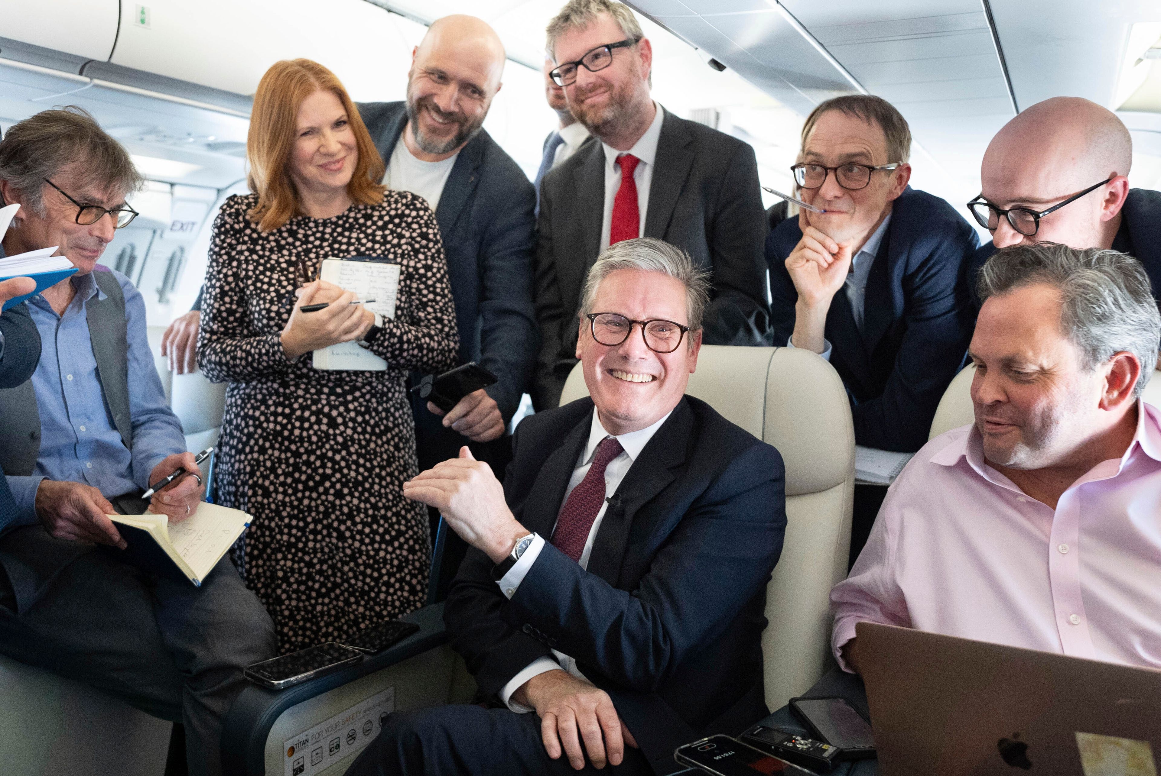 Britain's Prime Minister Keir Starmer, center, talks to the media on board his plane as he flies to Washington DC., Thursday Sept. 12, 2024. (Stefan Rousseau/Pool via AP)