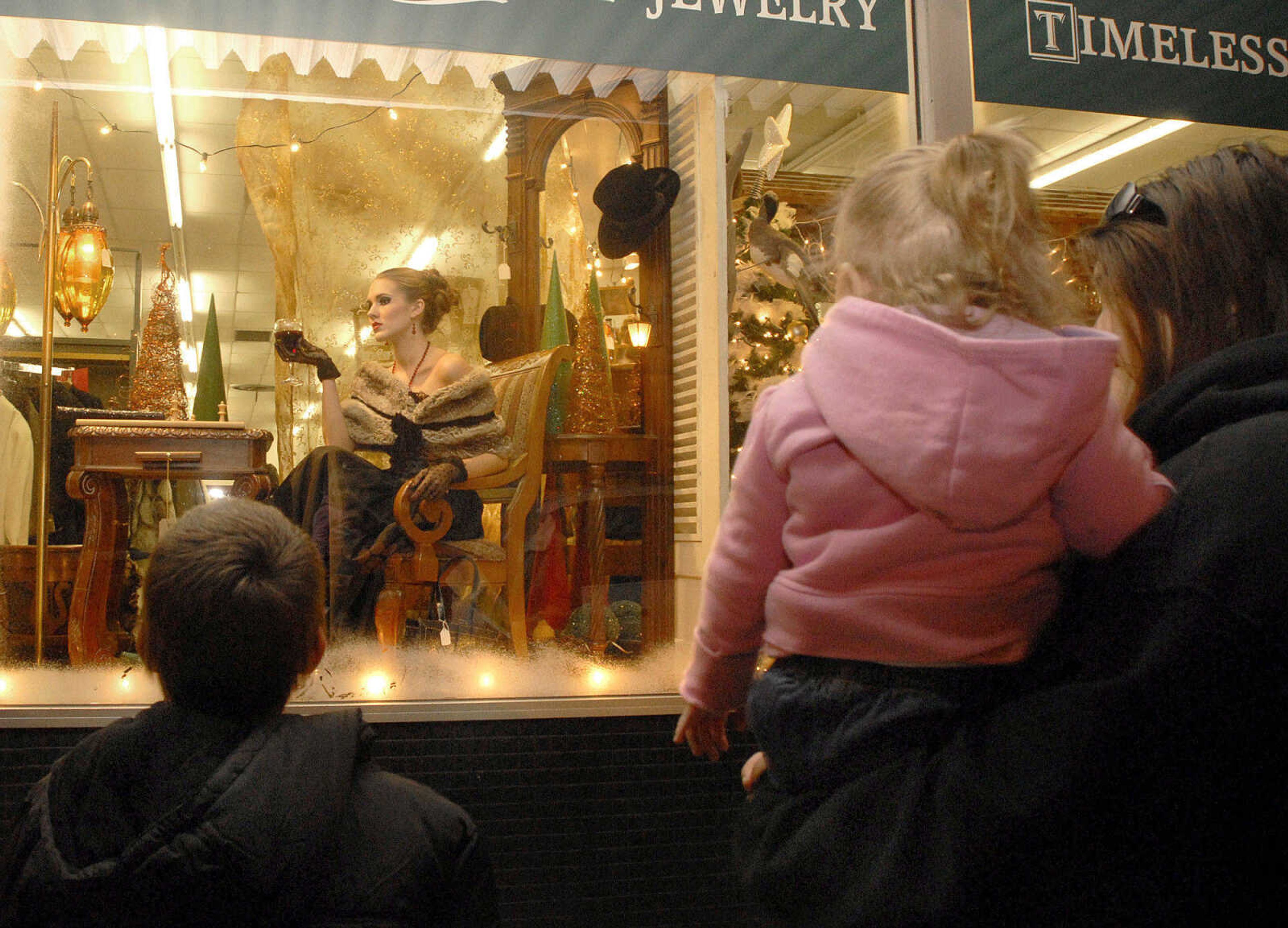 LAURA SIMON ~ lsimon@semissourian.com
Passers by are take back by the live models posing as mannequins in the storefront of Pastimes Antiques Friday, Dec. 2, 2011 during Old Town Cape's annual Downtown Christmas Open House.