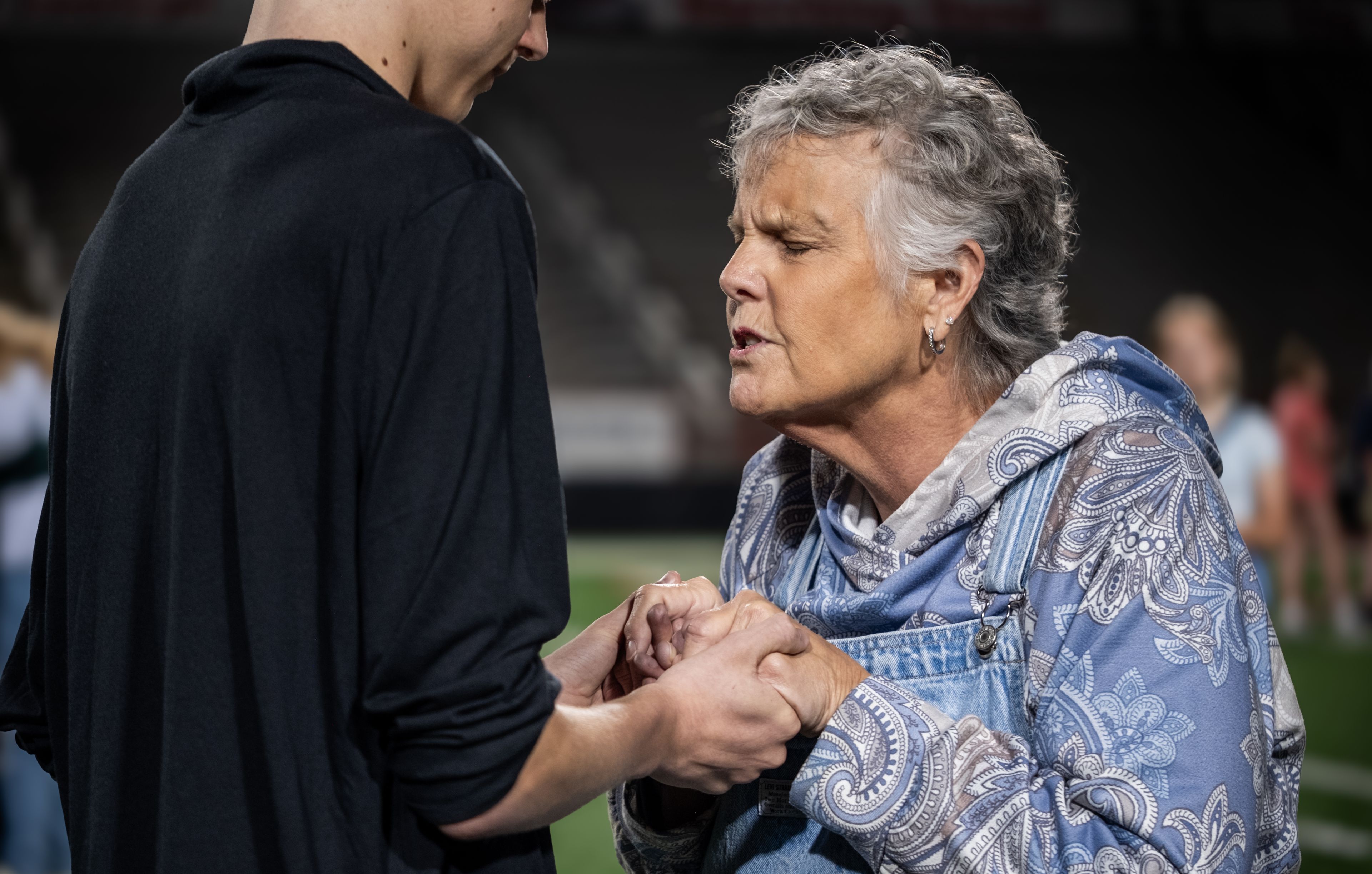 Community members join in prayer on the field.
