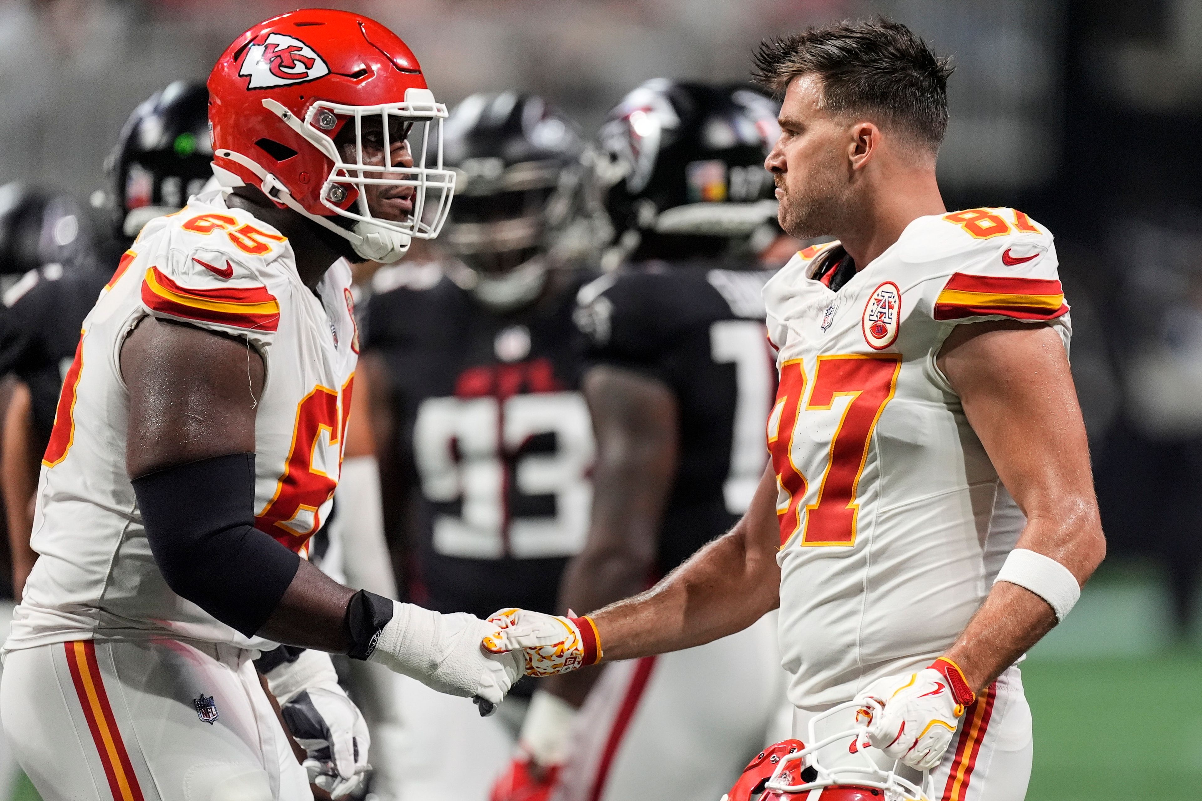 Kansas City Chiefs tight end Travis Kelce (87) speaks with Trey Smith (65) during the second half of an NFL football game against the Atlanta Falcons, Sunday, Sept. 22, 2024, in Atlanta. (AP Photo/John Bazemore)