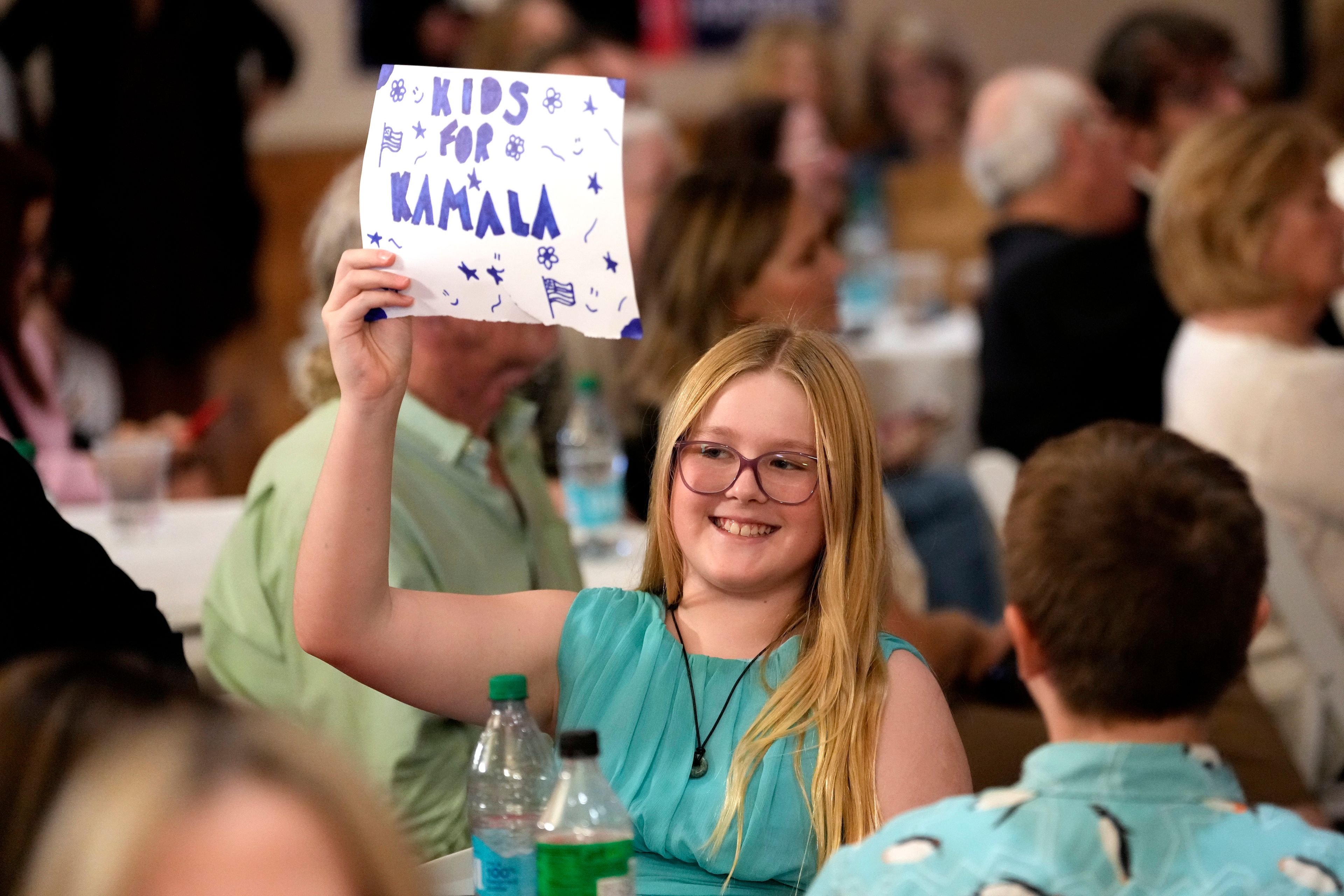 A young supporter holds up a sign as Democratic presidential nominee Vice President Kamala Harris speaks at a campaign event Friday, Oct. 11, 2024, at the Grayhawk Golf Club in Scottsdale, Ariz. (AP Photo/Ross D. Franklin)