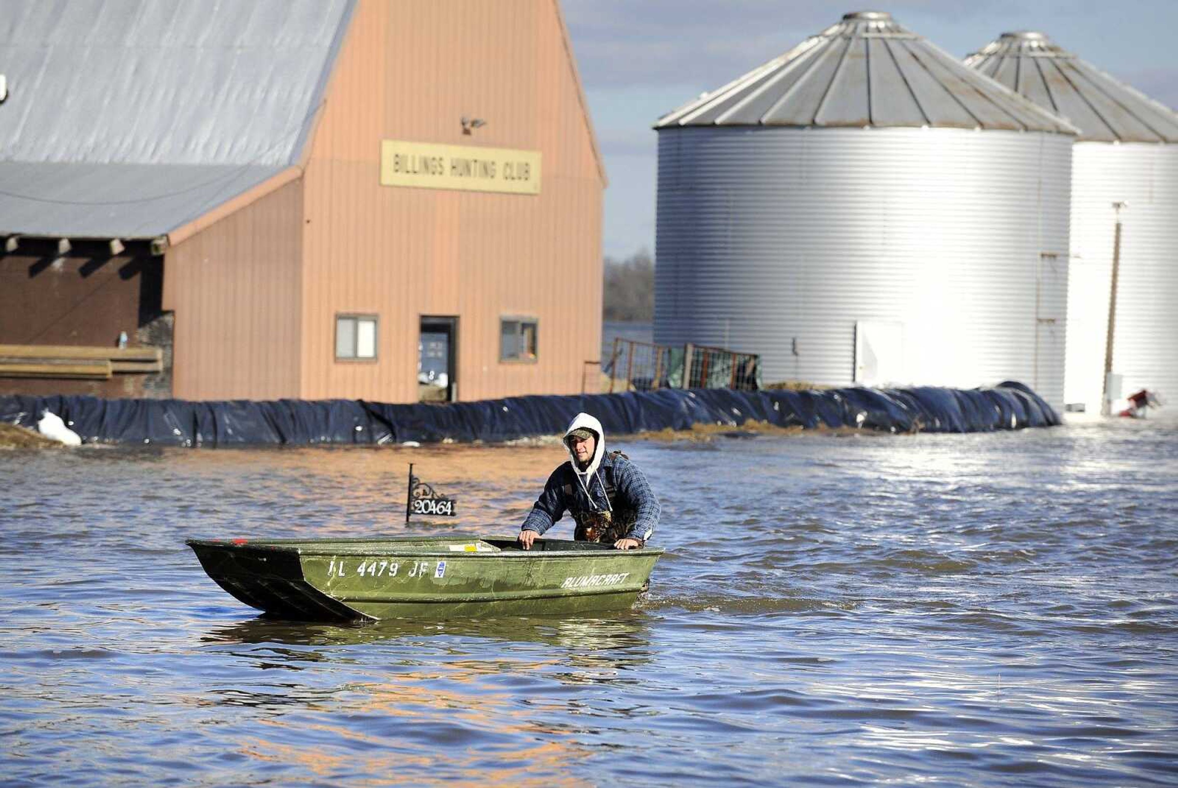 Zak Billings walks a boat through the floodwater back to his truck Monday after taking his father, Scott, out to the Billings Hunting Club in Olive Branch, Illinois. (Laura Simon)