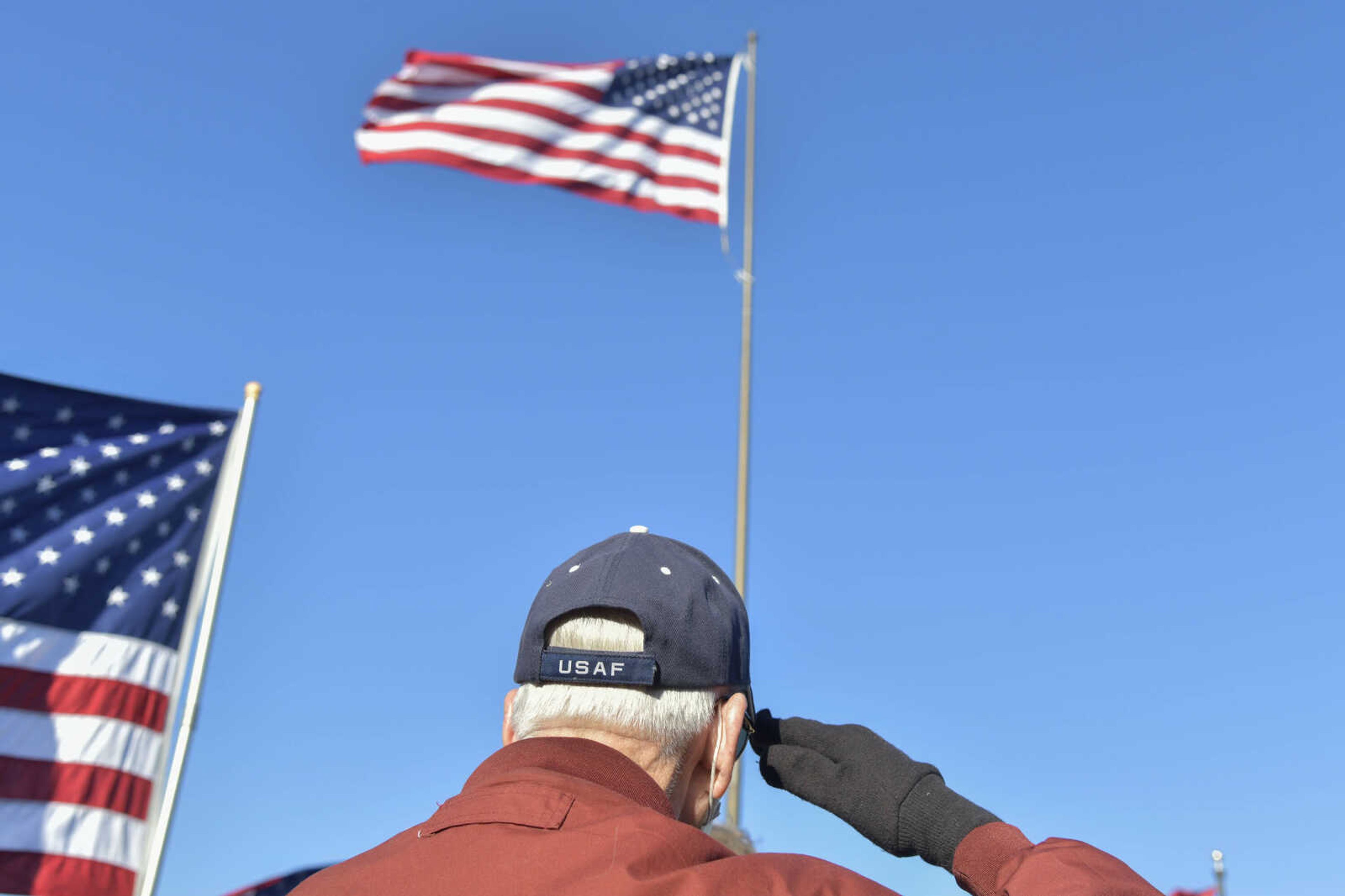 A man in the crowd salutes during the national anthem at Cape County Park North in Cape Girardeau on Wednesday, Nov. 11, 2020.