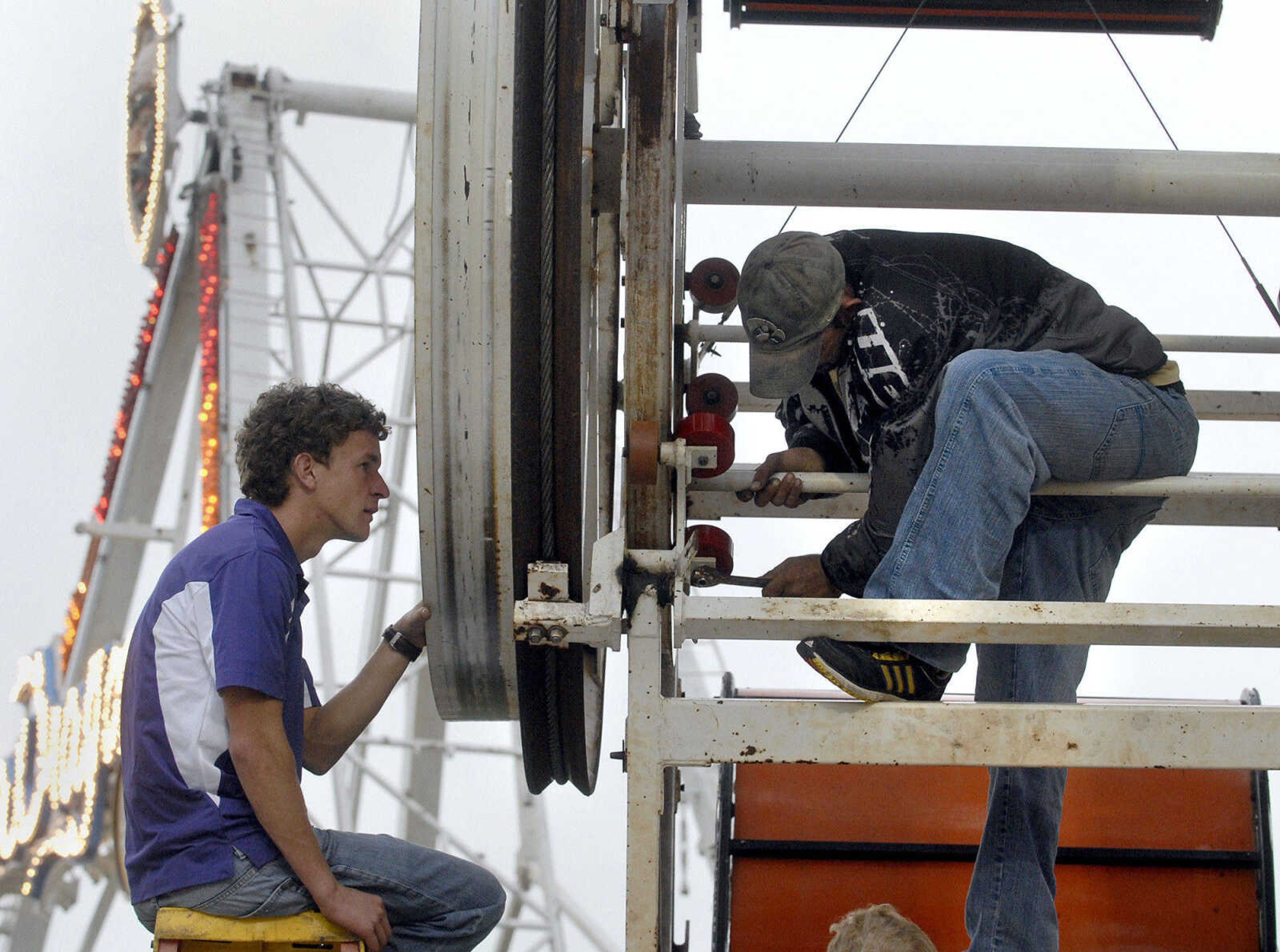 LAURA SIMON ~ lsimon@semissourian.com
Marcel du Plessis, left, and Travis Depres with Lowery Carnival Co. perform maintenance on the Chainsaw ride Saturday, September 17, 2011 during the final day of the SEMO District Fair at Arena Park in Cape Girardeau.