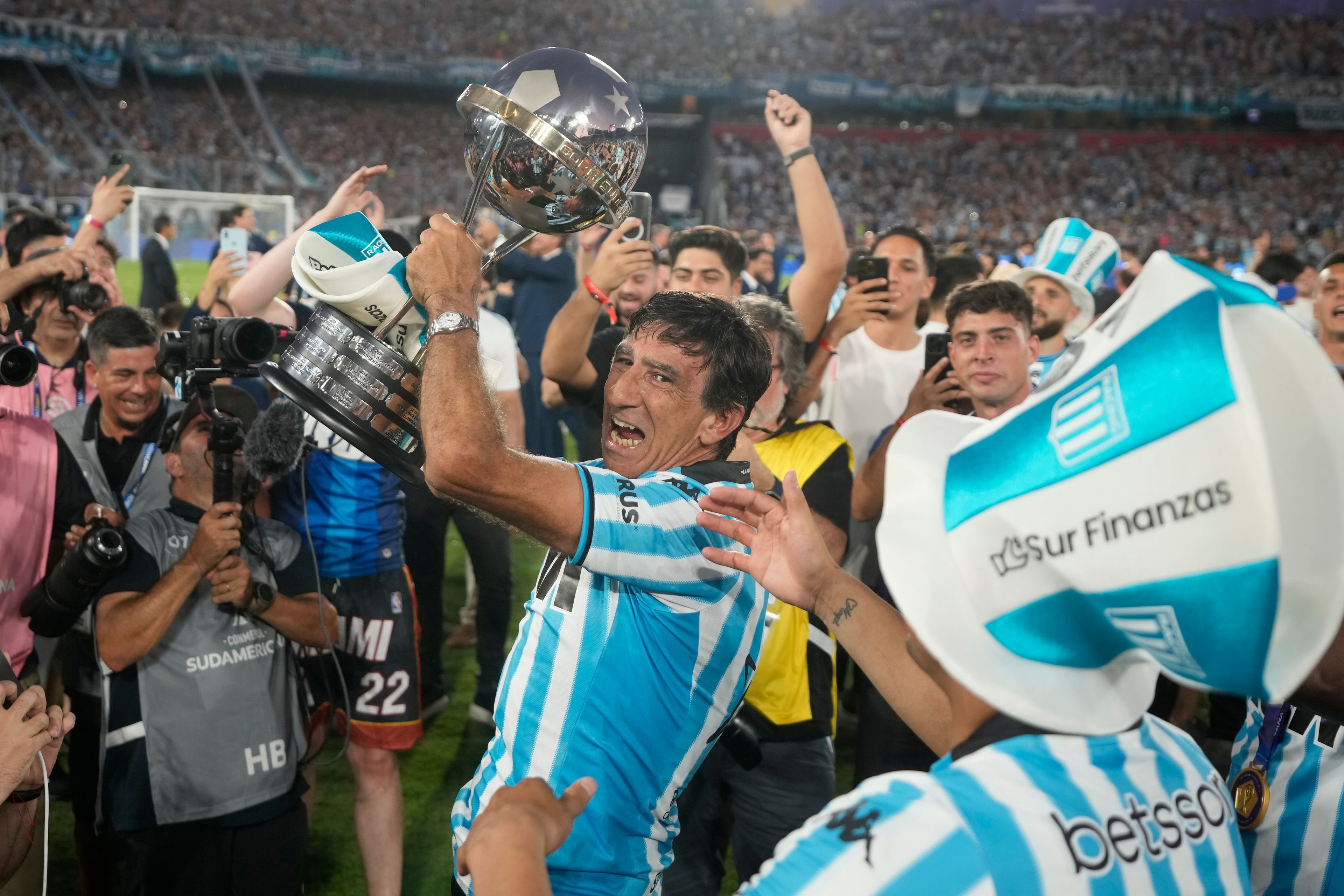 Coach Gustavo Costas of Argentina's Racing Club celebrates with the trophy after winning the Copa Sudamericana final soccer match against Brazil's Cruzeiro in Asuncion, Paraguay, Nov. 23, 2024. (AP Photo/Jorge Saenz)