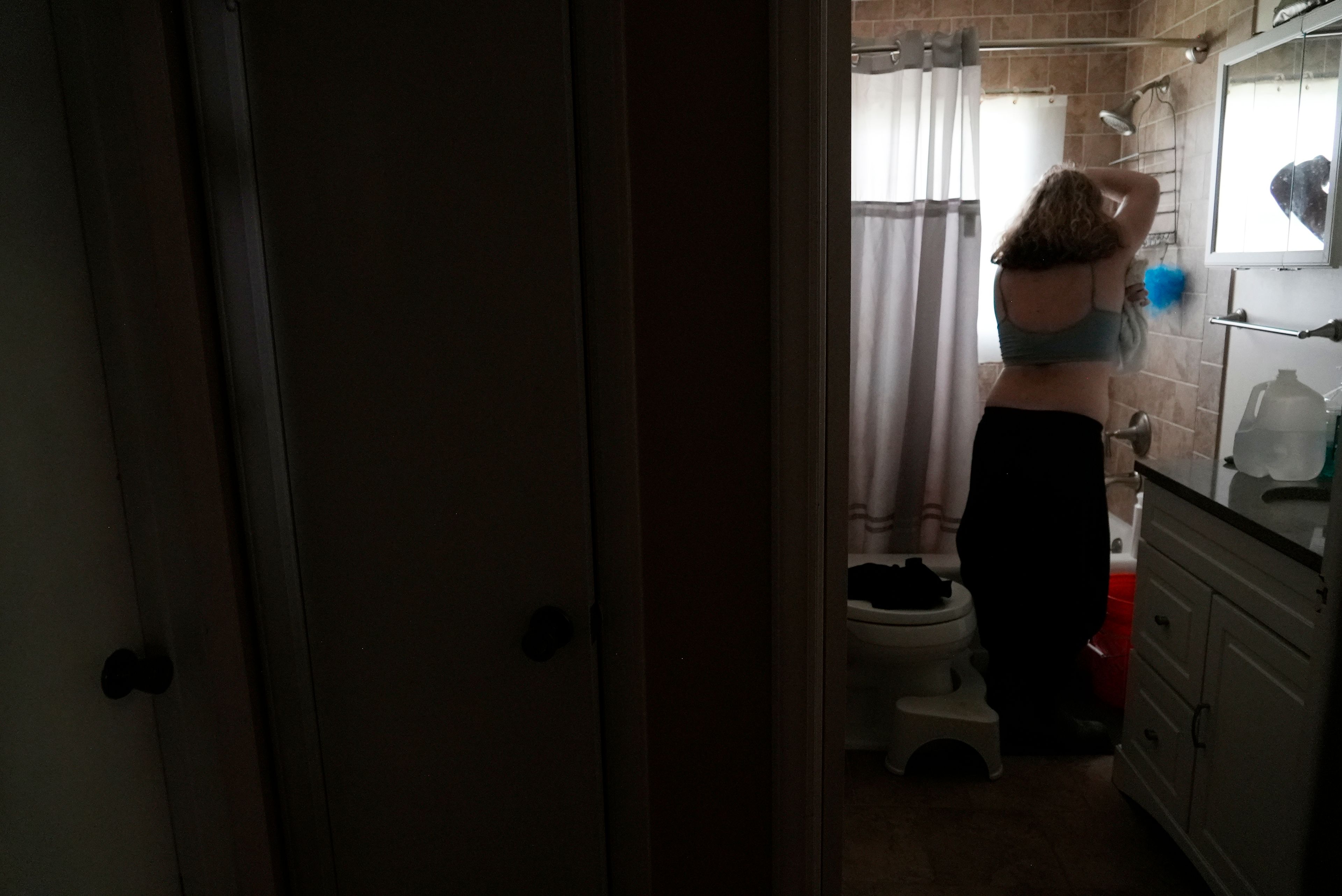 Marilyn Edwards, 17, uses a facecloth to bathe Thursday, Oct. 3, 2024 in Asheville, North Carolina. Her family hasn't had water since Hurricane Helene struck the area and damaged critical infrastructure. (AP Photo/Brittany Peterson)