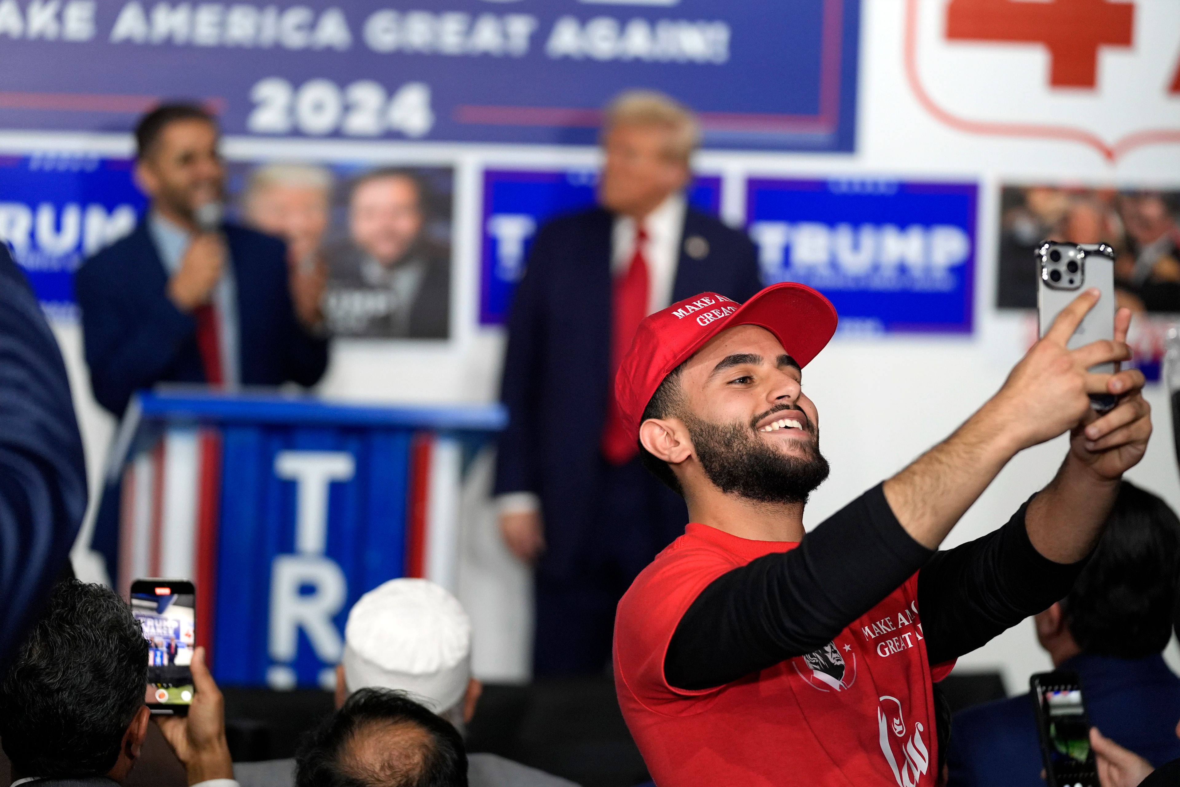 A supporter takes a photo as Republican presidential nominee former President Donald Trump visits a campaign office, Friday, Oct. 18, 2024, in Hamtramck, Mich. (AP Photo/Evan Vucci)