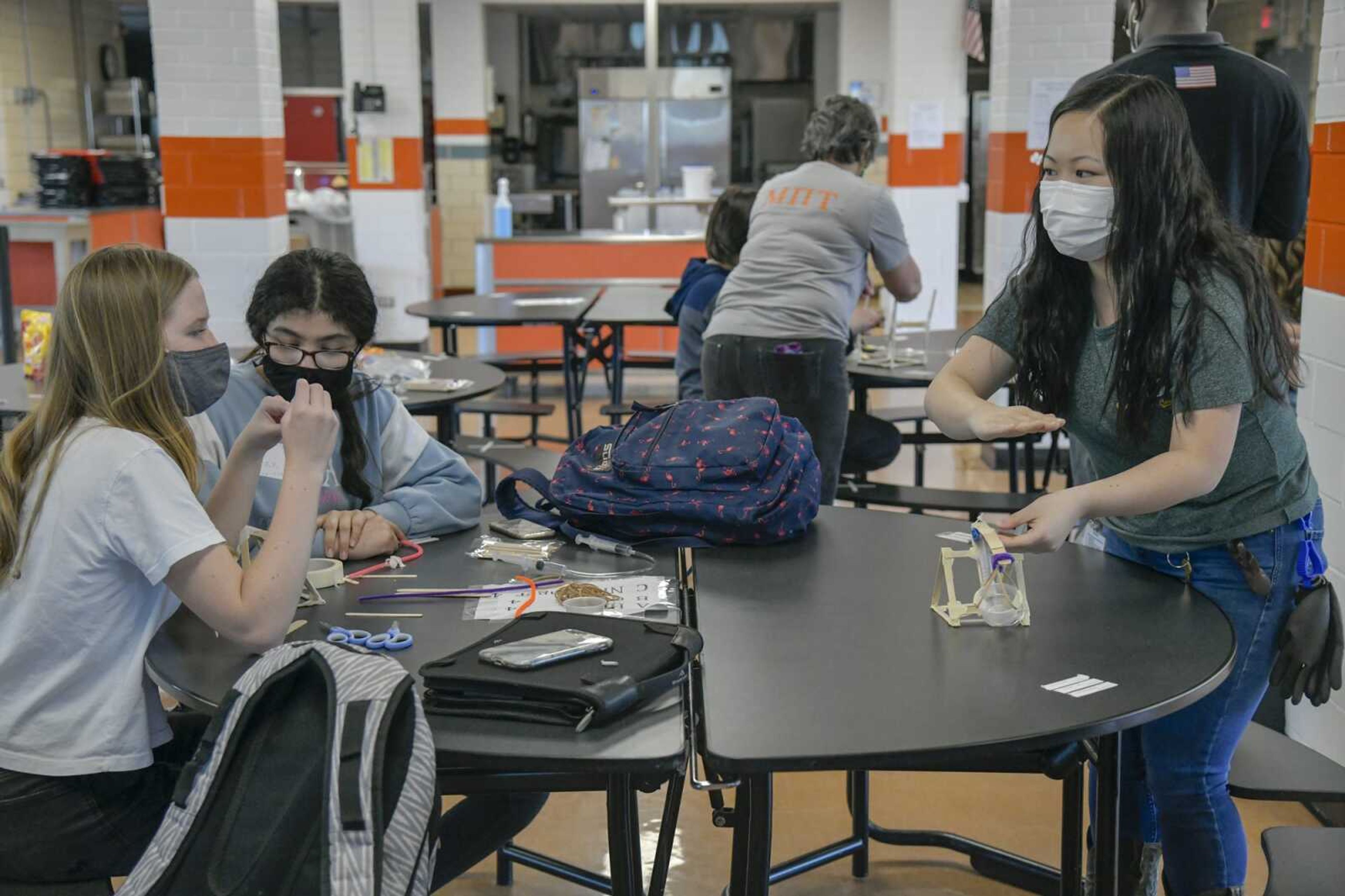 Process engineer and Mission Possible team coordinator Christine Lin, right, helps students Vivan Nordin, 13, and Sankriti Srikant, 12, with their lift project by demonstrating a model during Thursday's Mission Possible meeting at Cape Girardeau Central Junior High School. Students in sixth, seventh and eighth grade can take part in the program run by local Procter & Gamble staff after school to learn more about engineering.