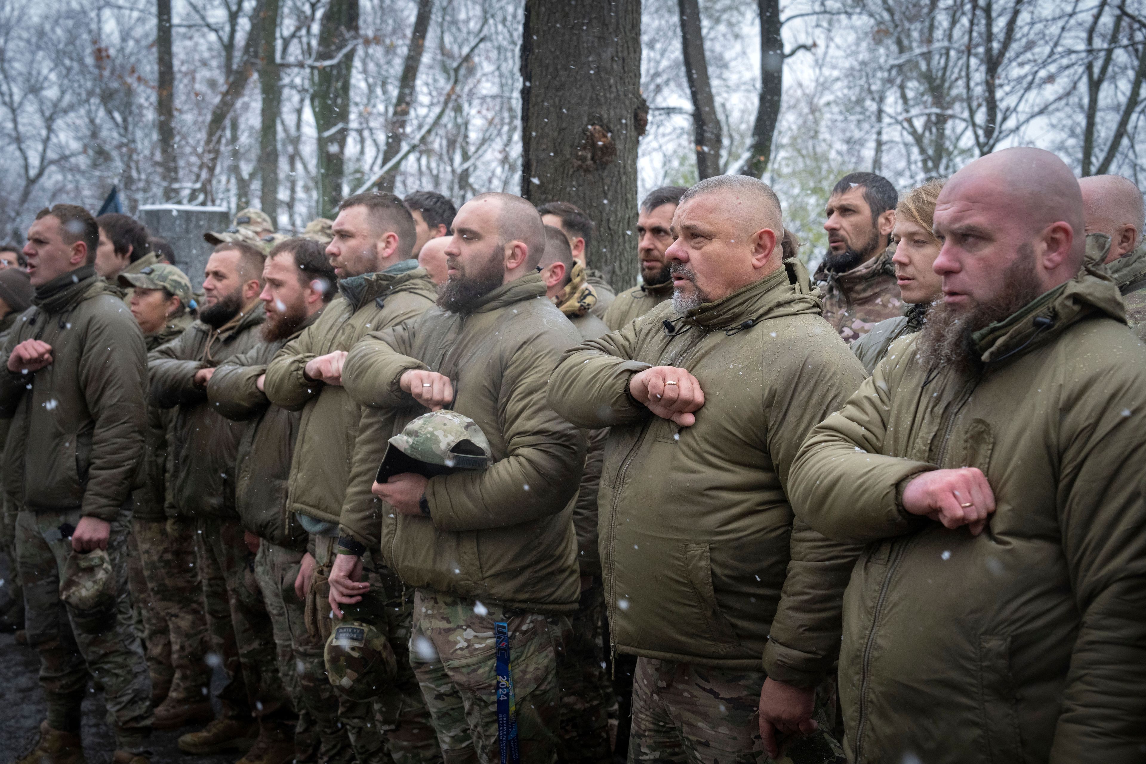 Soldiers of Ukraine's 1st Separate Mechanised Battalion "Da Vinci Wolves" named after Dmytro Kotsiubailo, callsign Da Vinci, sing the Ukrainian anthem in the honour guard at his tomb during opening ceremony for Kotsiubailo monument in Kyiv, Ukraine, Thursday, Nov. 21, 2024. Kotsiubailo was killed in a battle with the Russian troops last March. (AP Photo/Efrem Lukatsky)