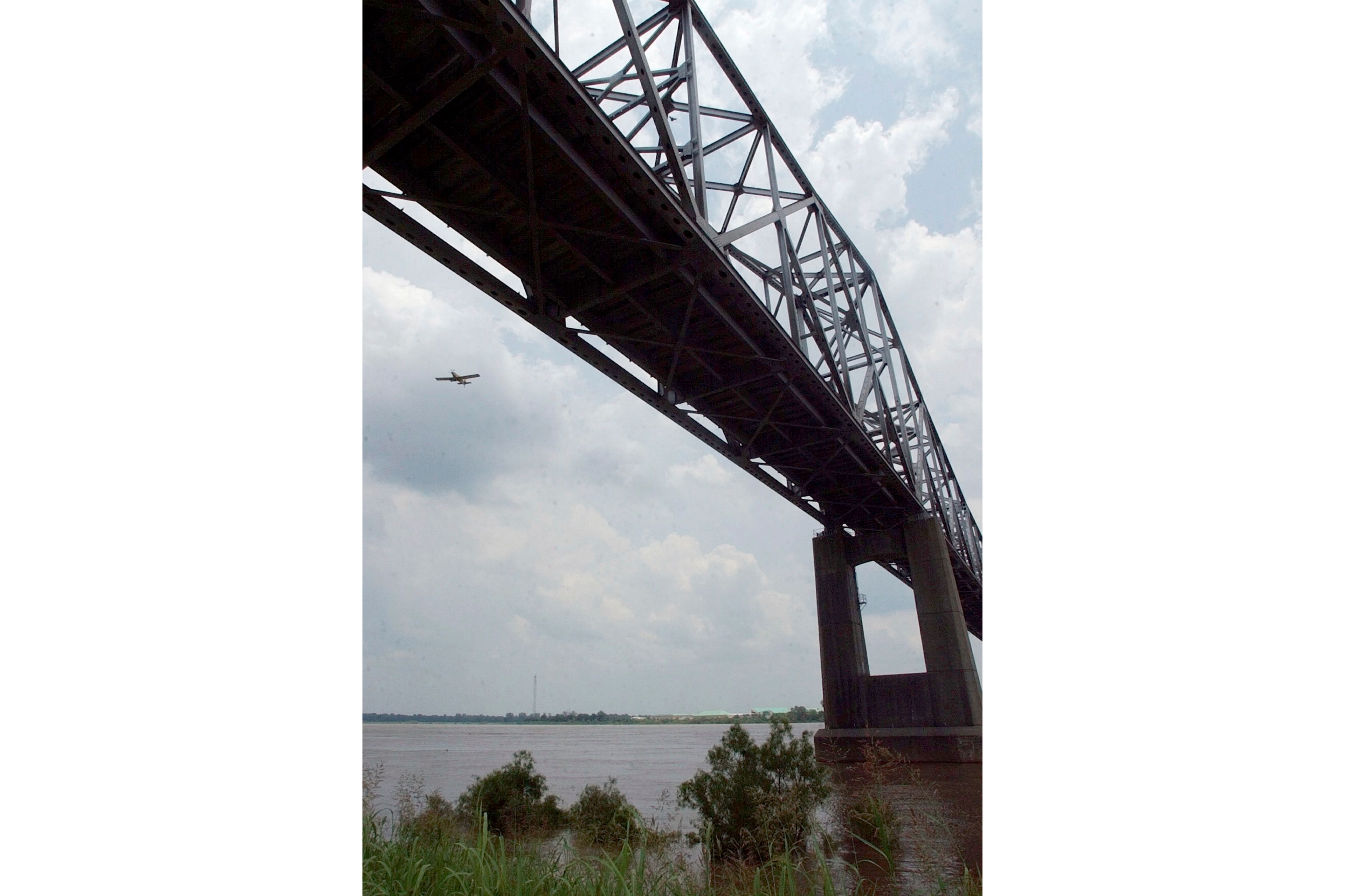 FILE - An agricultural airplane flies near the Highway 49 bridge over the Mississippi River near Helena, Ark., on June 10, 2004. (AP Photo/Danny Johnston, File)