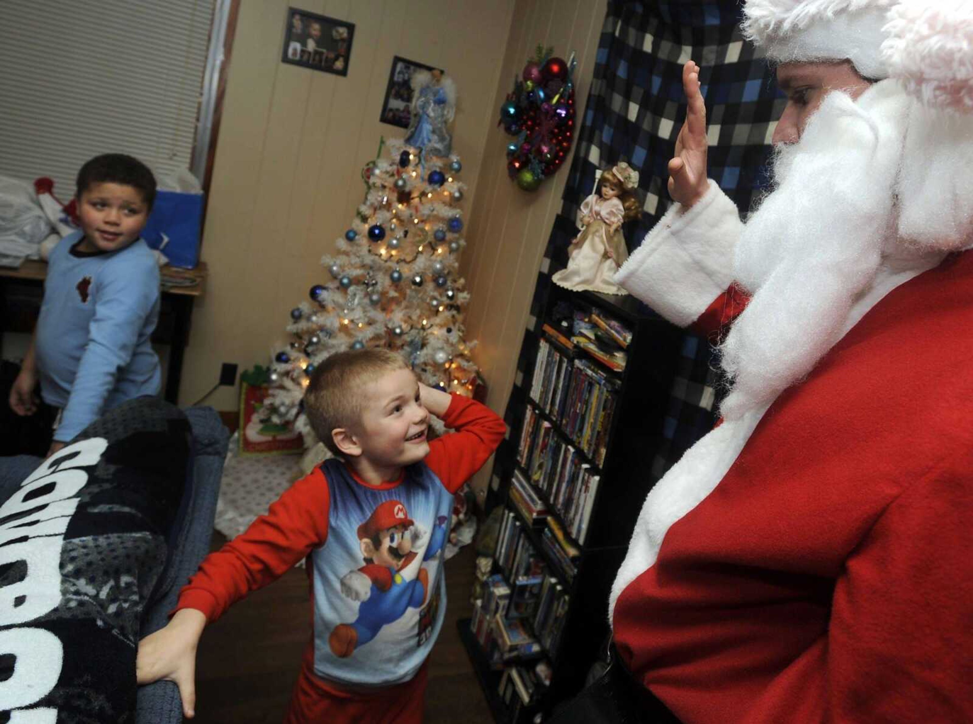 Santa and his helpers have delivered Christmas cheer through the Toybox program for more than 40 years, including this happy greeting in 2013. (Fred Lynch)