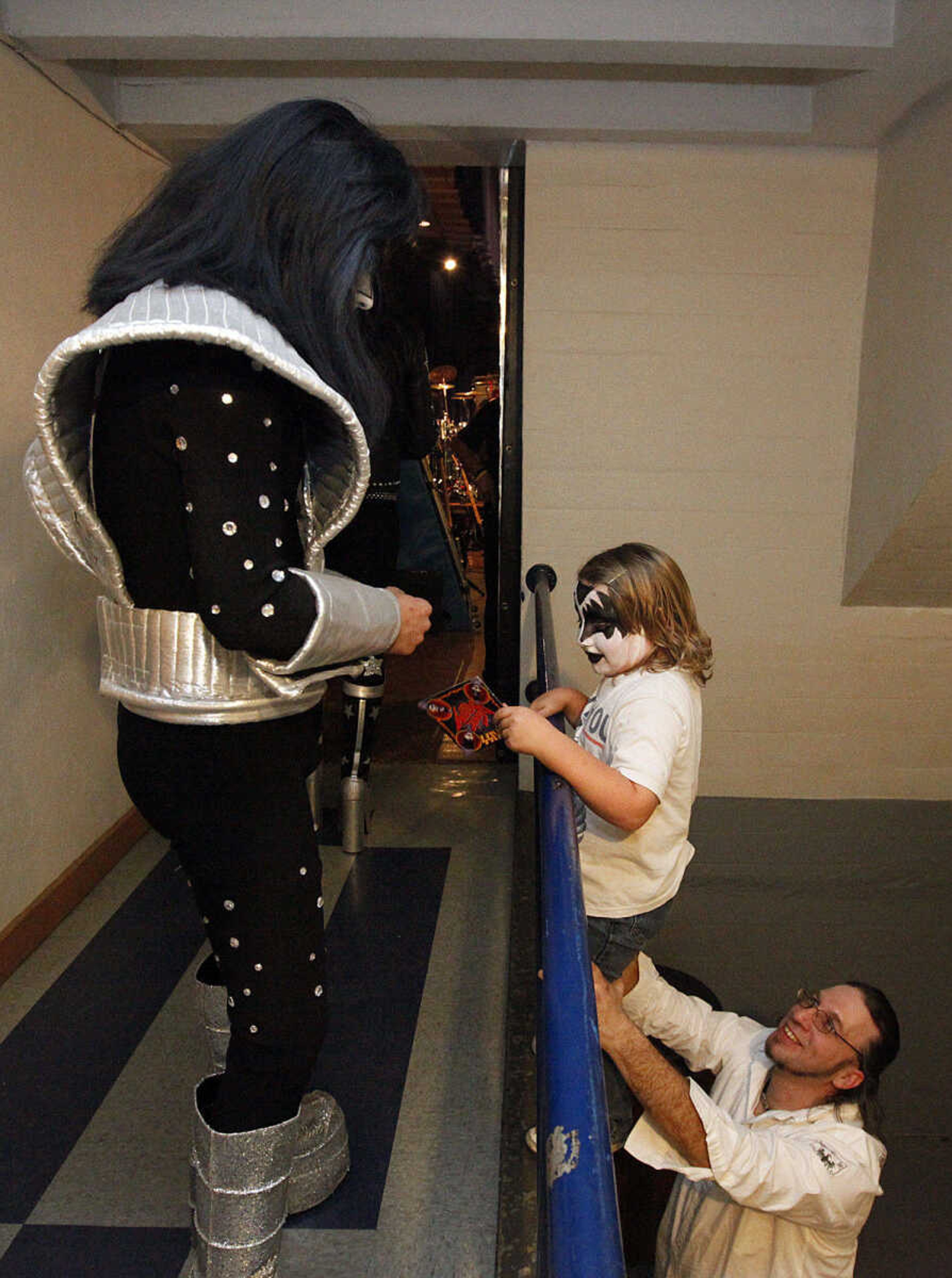 CHRIS MACKLER ~ photos@semissourian.com

Timexx Seabaugh holds up Jude Jaco, 5, to get his CD signed by KISSiT member Mini Me Frehley during the Kiss, AC/DC and Rod Stewart Tribute Concert held at the Arena Building on Saturday, Nov. 6, 2010, in Cape Girardeau.