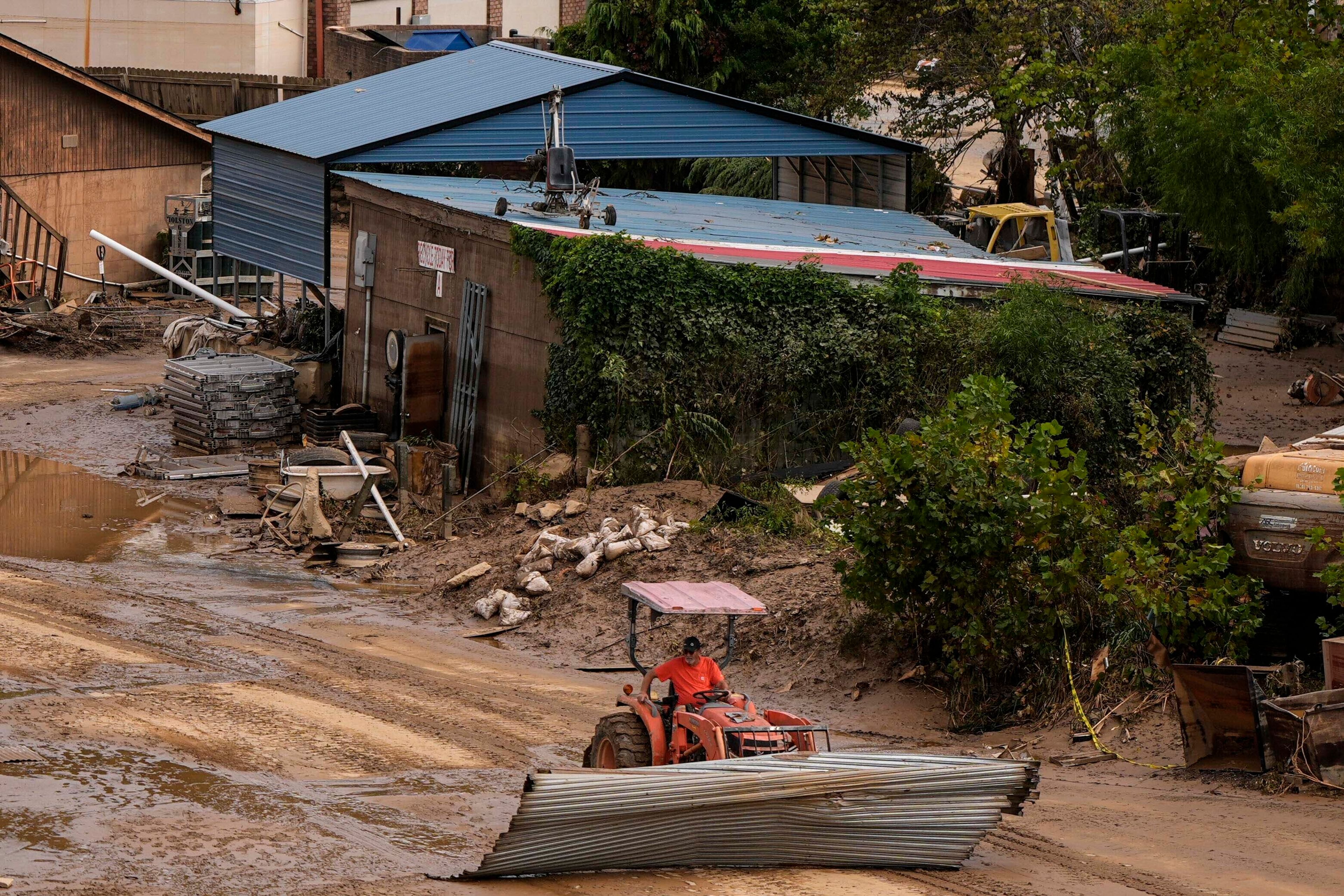 A worker moves debris in the aftermath of Hurricane Helene, Monday, Sept. 30, 2024, in Asheville, N.C. (AP Photo/Mike Stewart)