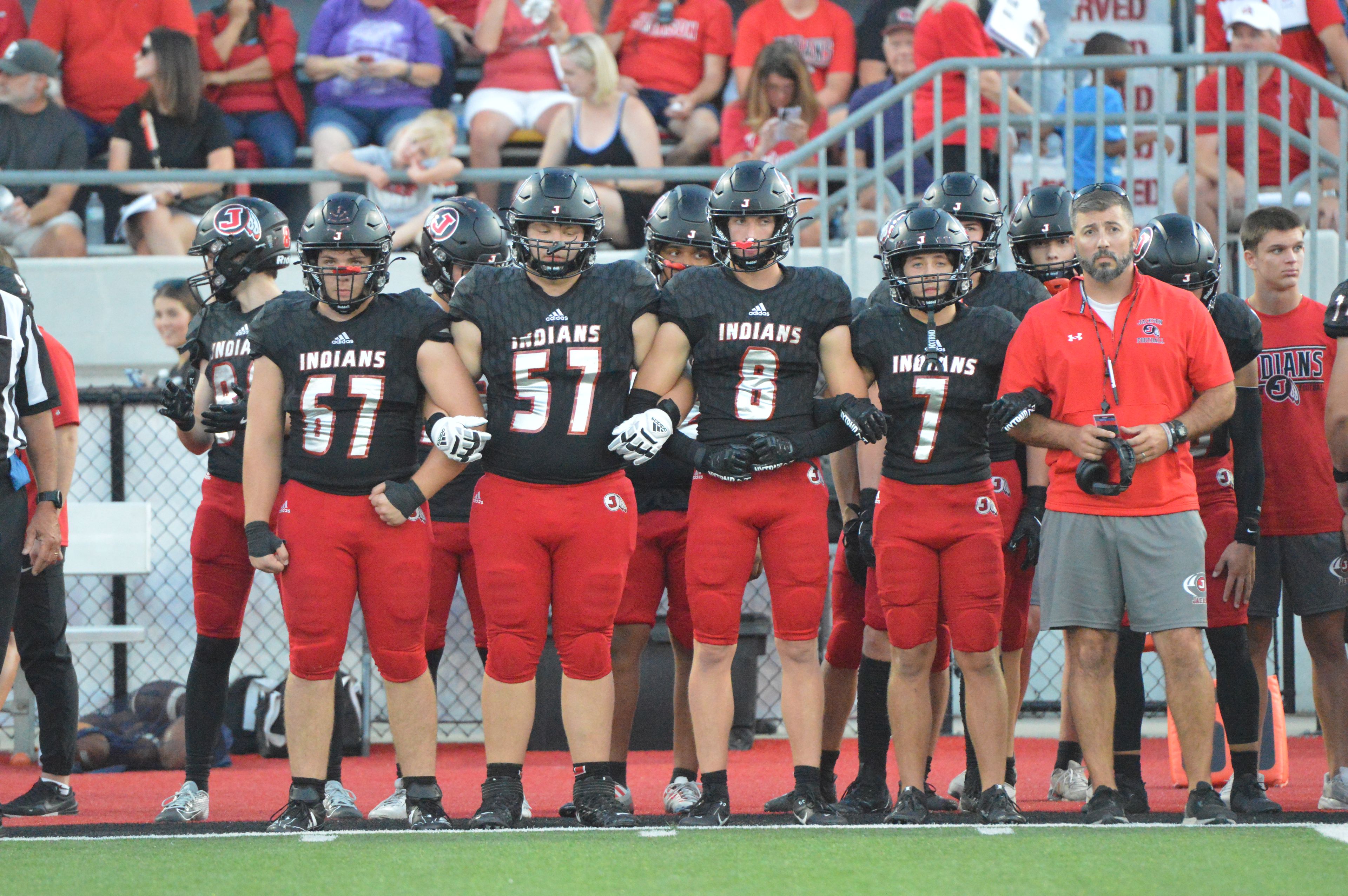 The Jackson team captains and head coach Ryan Nesbitt line up before the pregame coin toss against Farmington on Friday, Sept. 20.