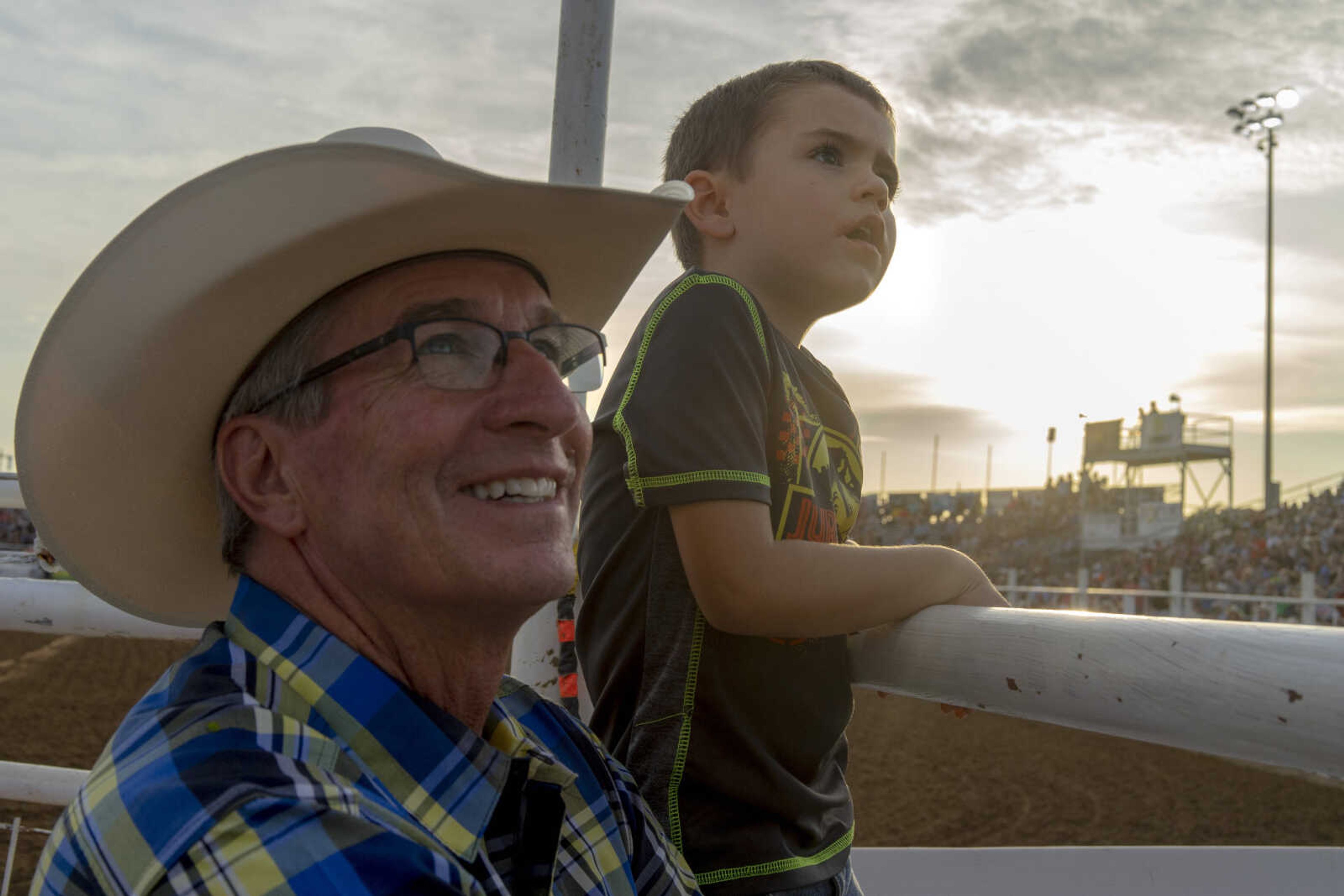 Justus Garrett, right, and his grandfather Larry watch a display video on Womanizer, a world-champion horse who would soon feature in the show during the last night of the Sikeston Jaycee Bootheel Rodeo Saturday, Aug. 14, 2021,&nbsp;in Sikeston, Missouri.