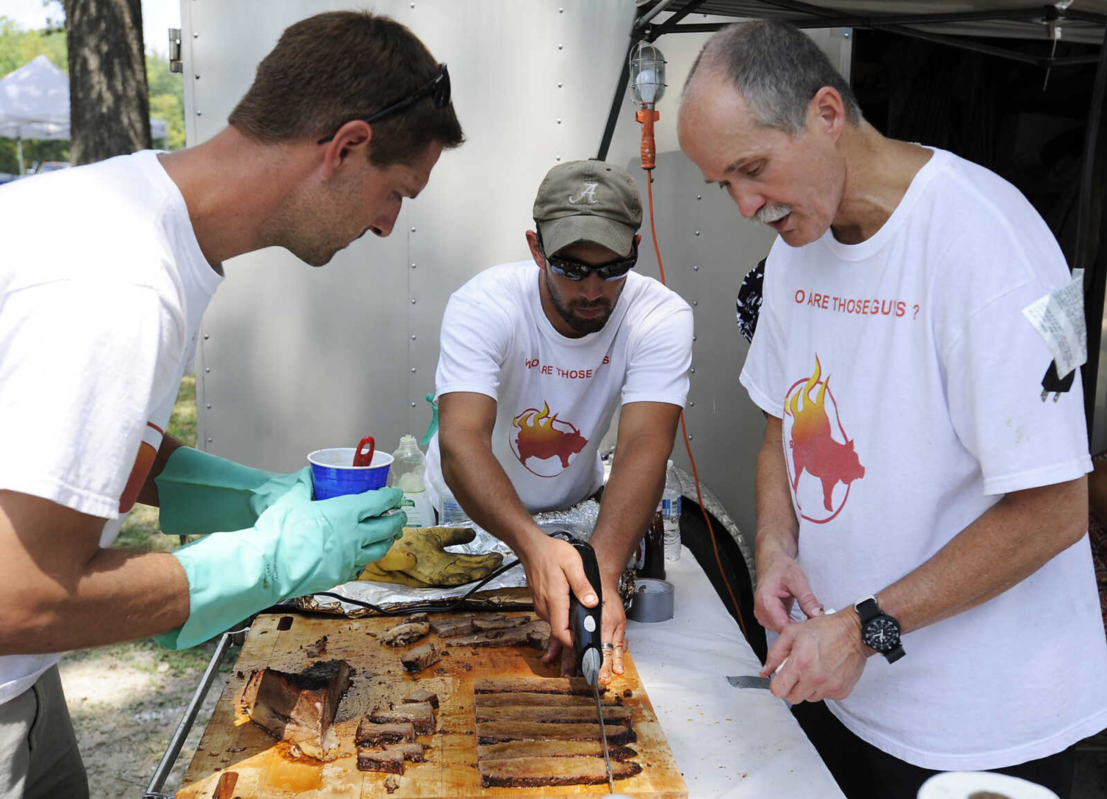 Sam Essner, left, Brandon Harvel and Luke Landgraf work on the Who are Those Guys? team's brisket entry during the 21st annual Cape BBQ Fest Saturday, Aug. 24, at Arena Park in Cape Girardeau. The team was on of fifty-seven teams competed in the event which is sanctioned by the Kansas City Barbecue Society and sponsored by the Jaycees. The teams name is taken from a lne in the movie Butch Cassidy and the Sundance Kid starring Paul Newman and Robert Redford.