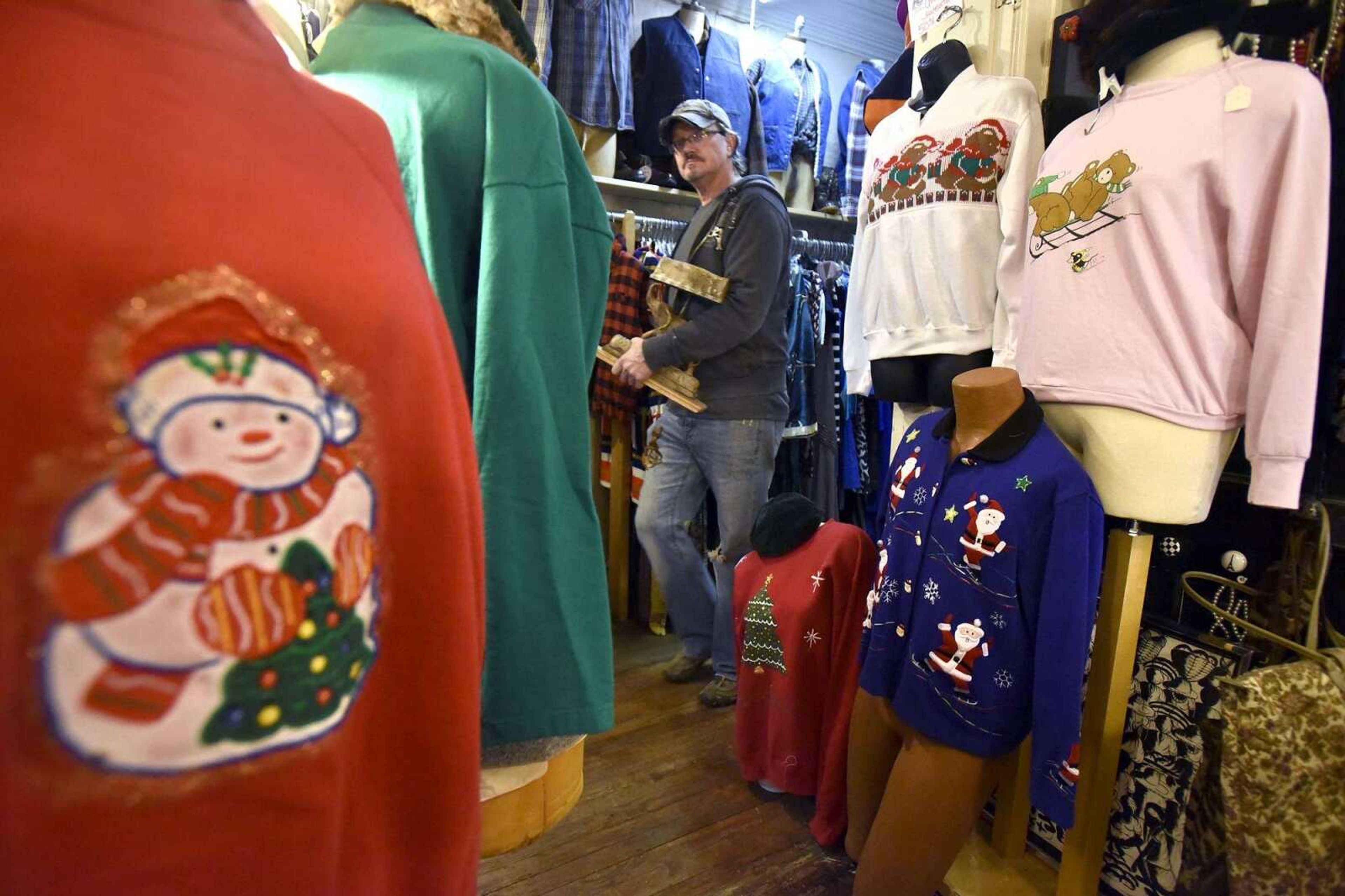 A shopper walks down the hallway past a selection of holiday sweaters at Annie Laurie's in Cape Girardeau on Monday.