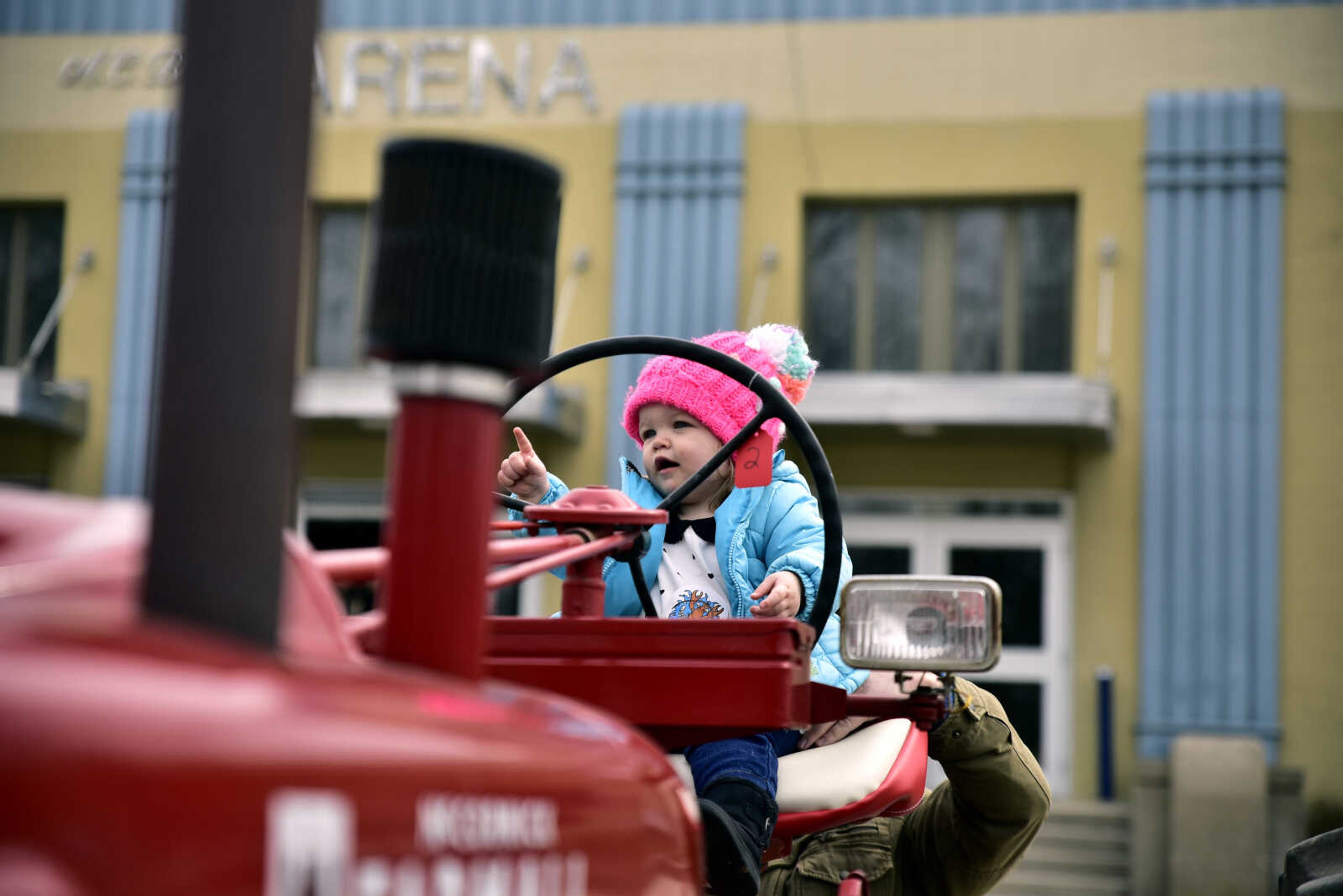 Elizabeth Peters, 1, is held on a tractor by her father Andy Peters at the Cousin Carl Farm Show on Saturday, March 10, 2018, at Arena Park in Cape Girardeau.