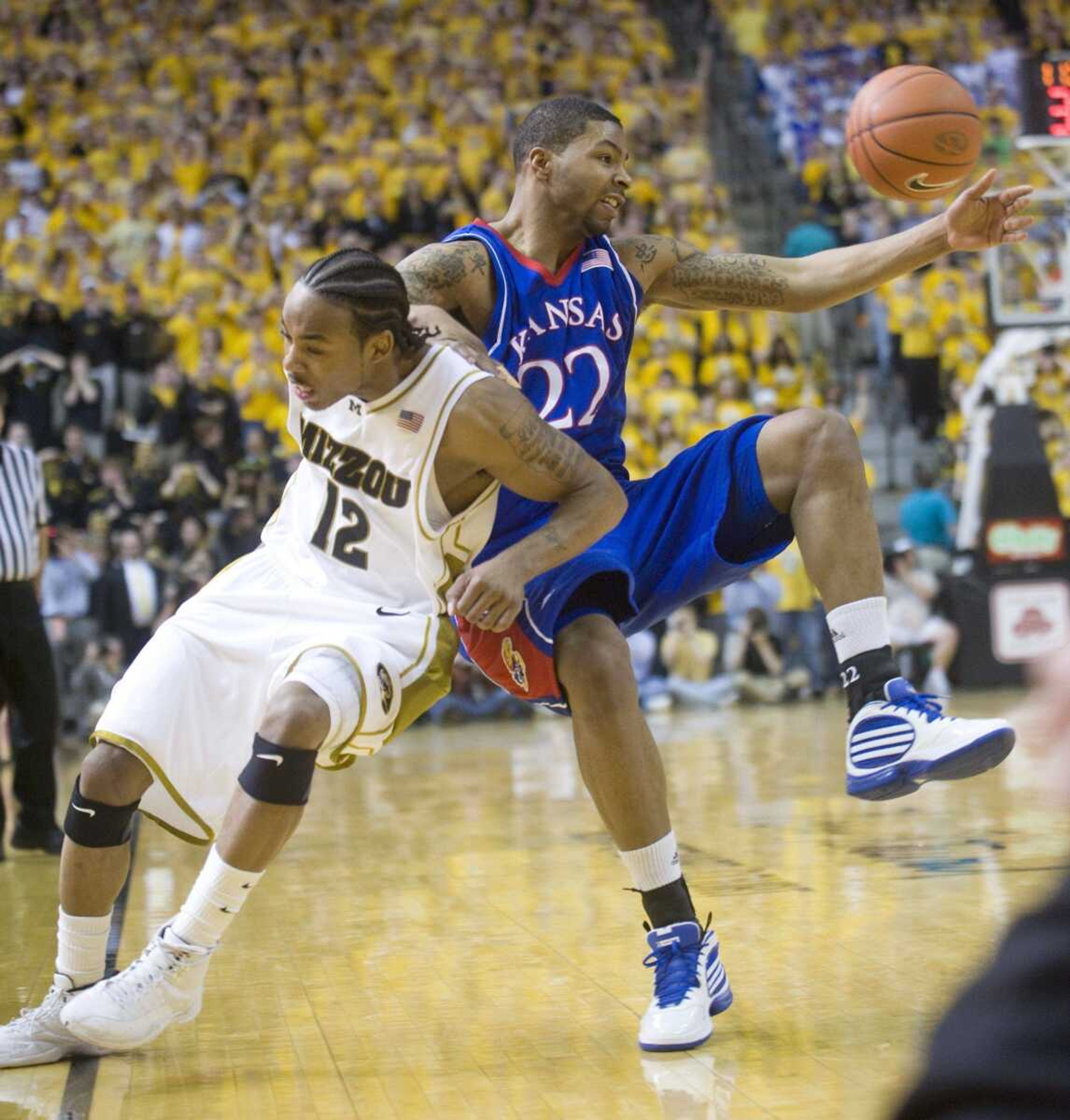 Missouri's Marcus Denmon, left, and Marcus Morris, right, collide as they battle for a loose ball during the second half of Saturday's Big 12 game in Columbia, Mo. (L.G. Patterson ~ Associated Press)