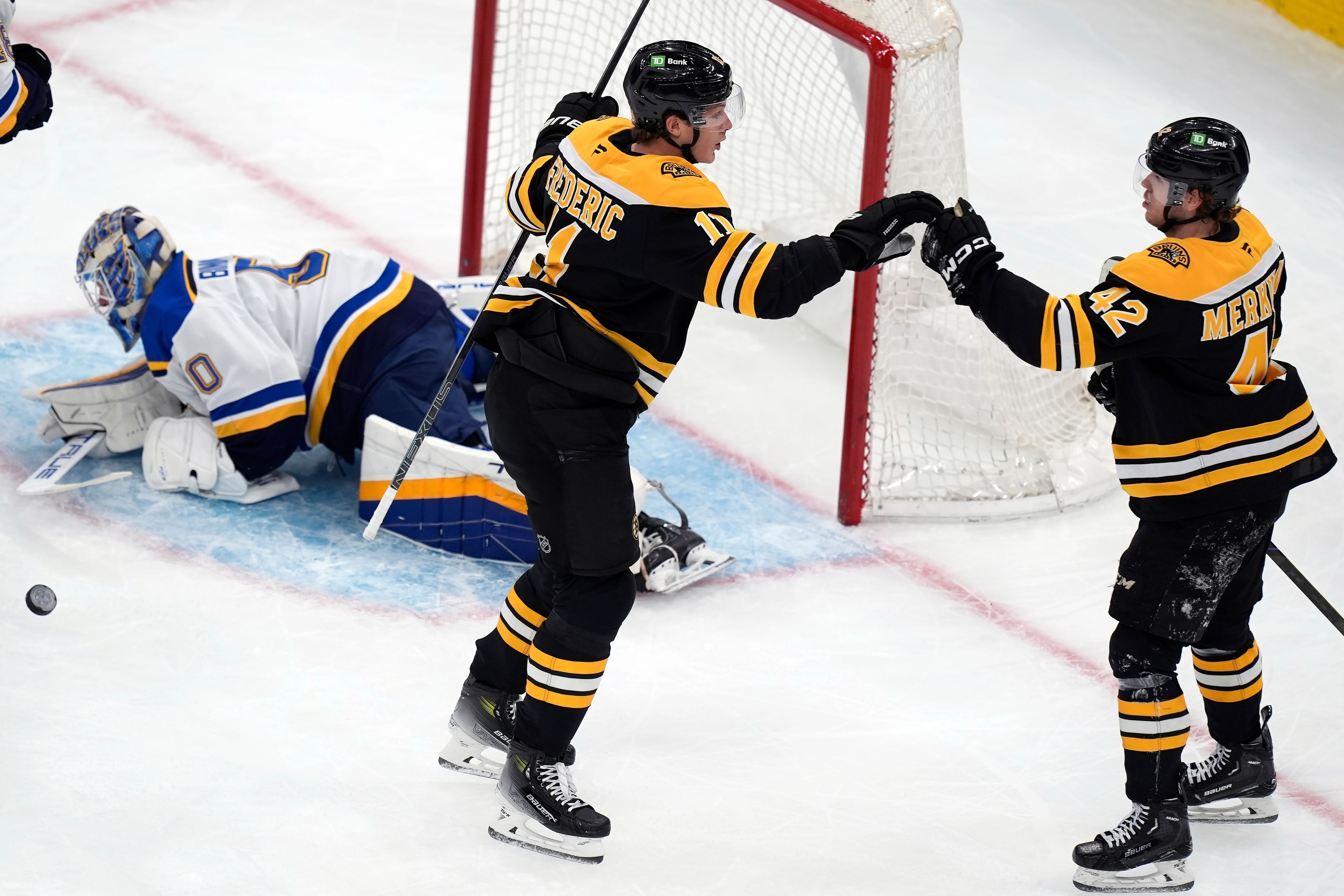 Boston Bruins' Trent Frederic (11) celebrates his first goal of the first period against St. Louis Blues' Jordan Binnington (50) with teammate Georgii Merkulov (42) during an NHL hockey game, Saturday, Nov. 16, 2024, in Boston. (AP Photo/Michael Dwyer)