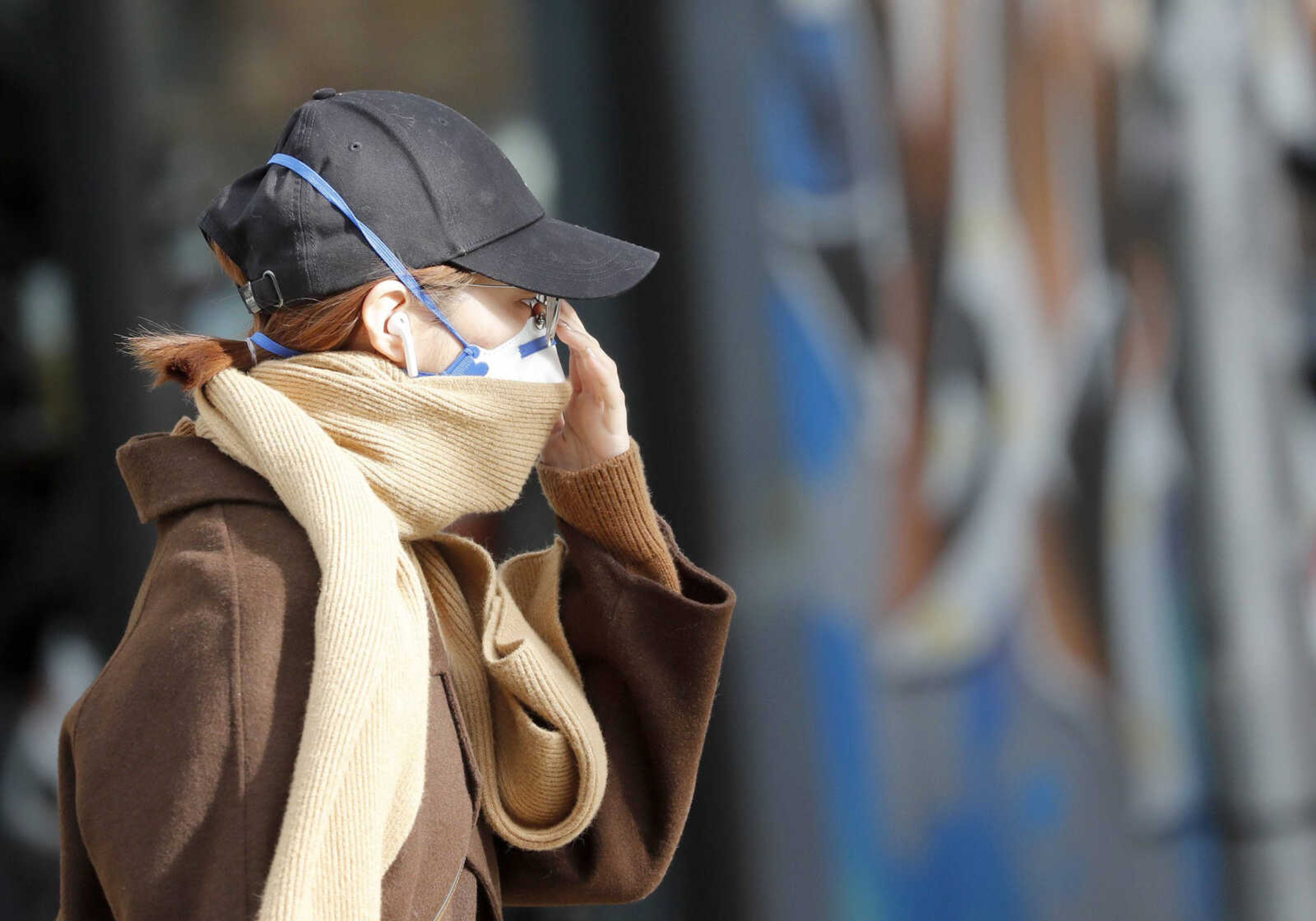 A woman with a face protection mask walks along the high street Tuesday in Brighton, Great Britain. Britain has declared the new coronavirus that emerged from China a "serious and imminent threat to public health" and announced new measures Monday to combat the spread of the disease.