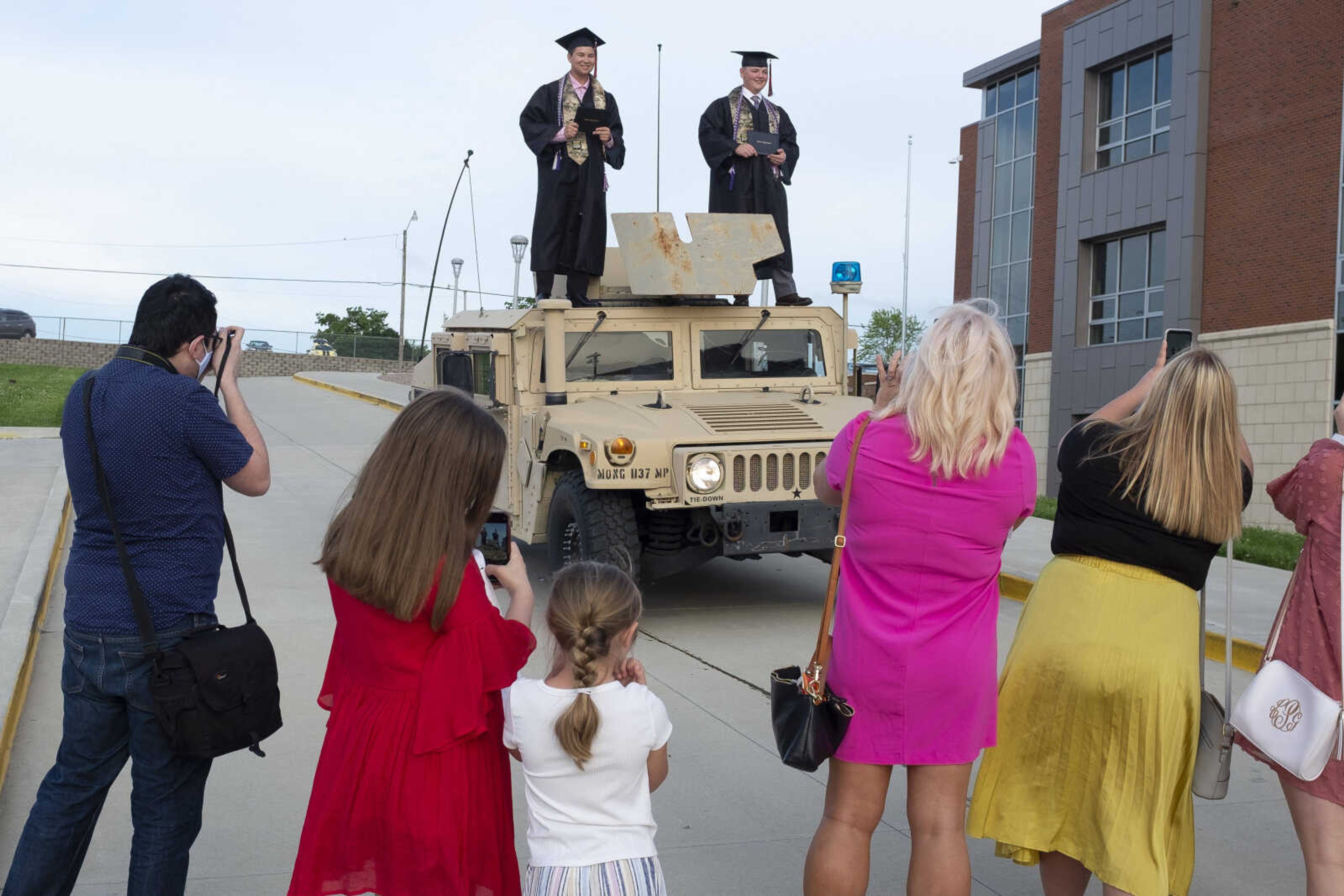 Jackson High School graduates Logan Wayne McClanahan (left on vehicle) and Caleb Scott Anderson have pictures taken while standing on top of a Humvee following an in-person military graduation ceremony and parade Friday, May 22, 2020, at Jackson High School.