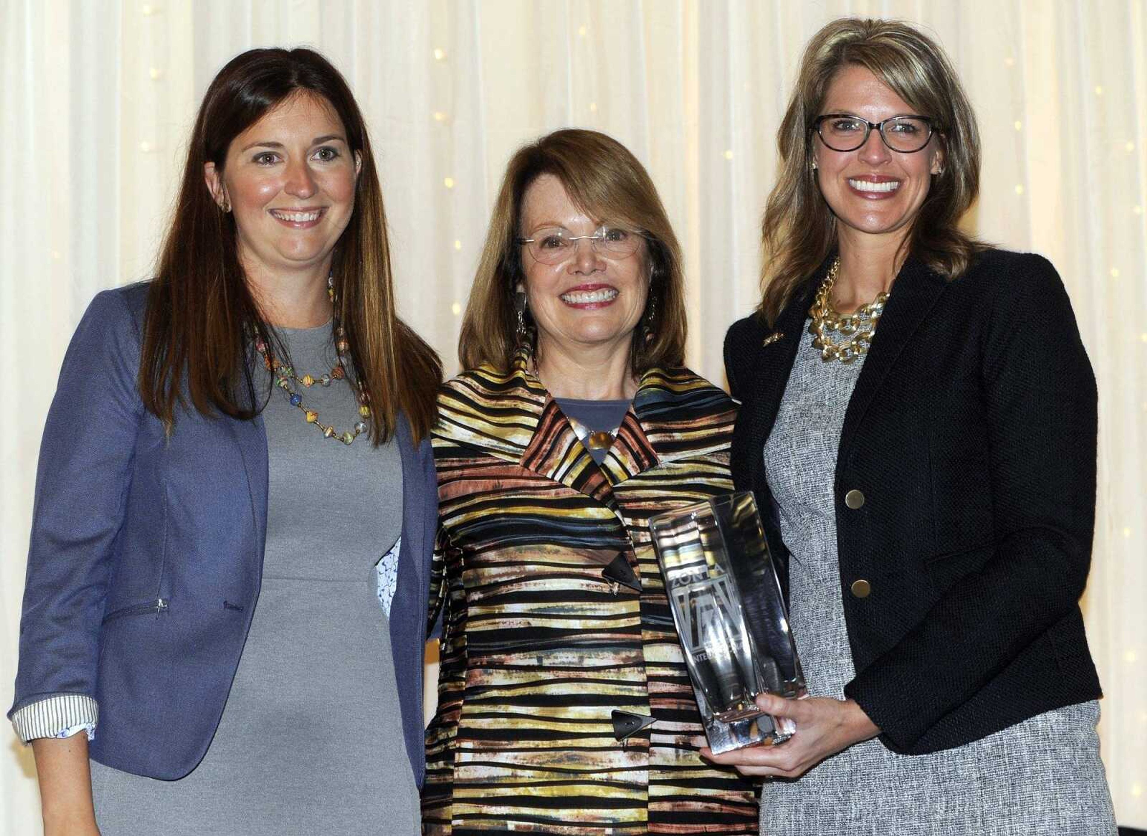 Patricia Ray, center, receives the Zonta Club's 2016 Woman of Achievement Award from Callie Welker, left, and Casey Crowell on Friday at Ray's Plaza Conference Center in Cape Girardeau.