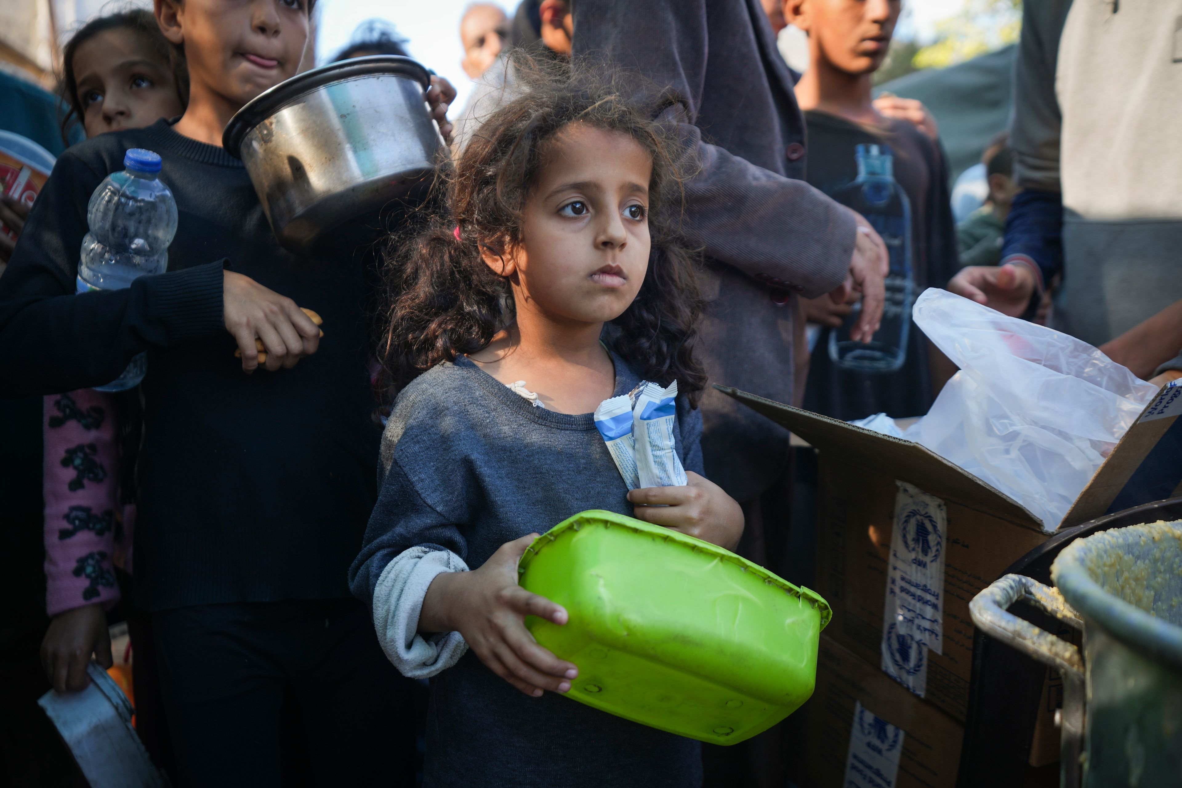 A Palestinian little girl queues for food in Deir al-Balah, Gaza Strip, Monday, Nov. 18, 2024. (AP Photo/Abdel Kareem Hana)