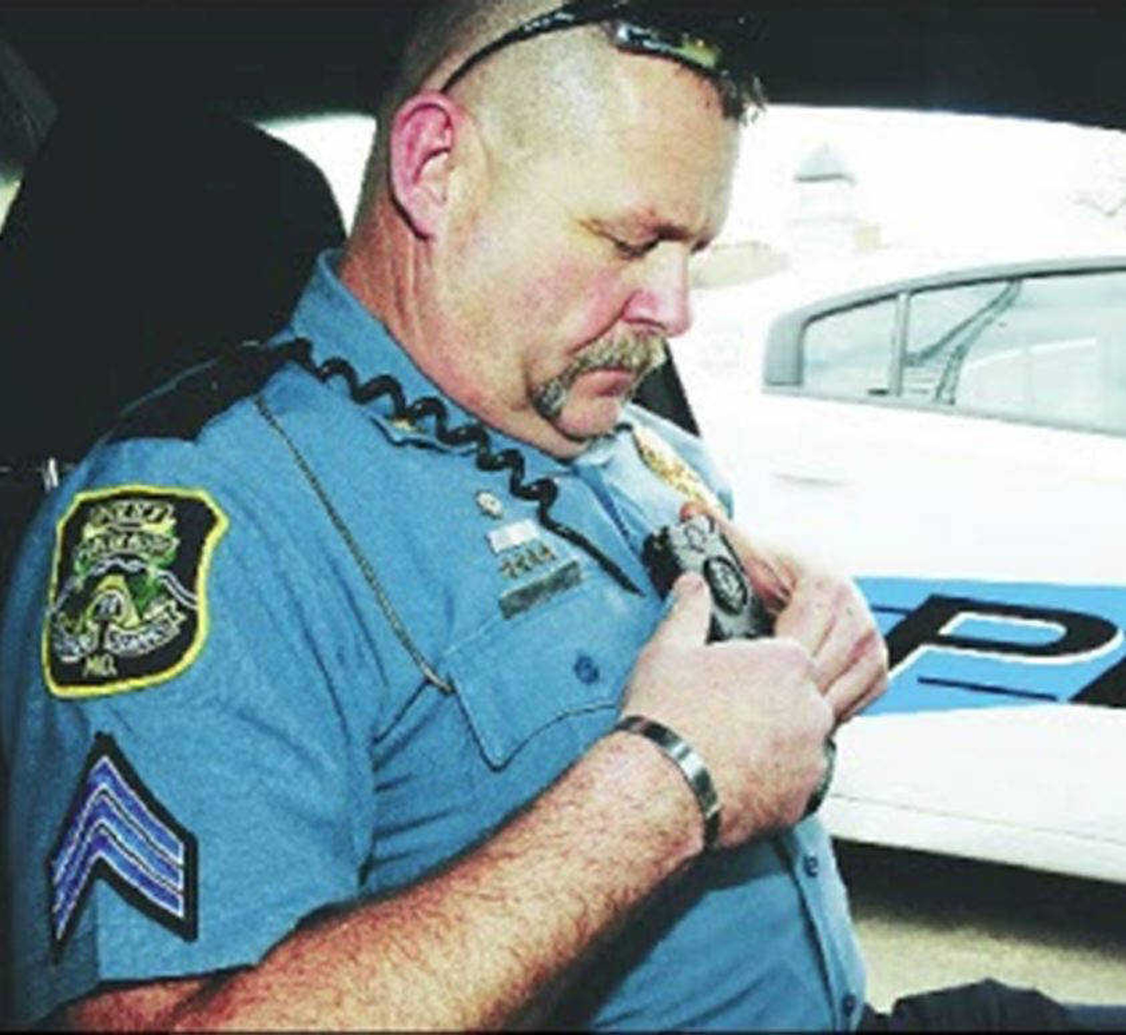 A Poplar Bluff police officer puts on a body camera before his shift. (Daily American Republic)