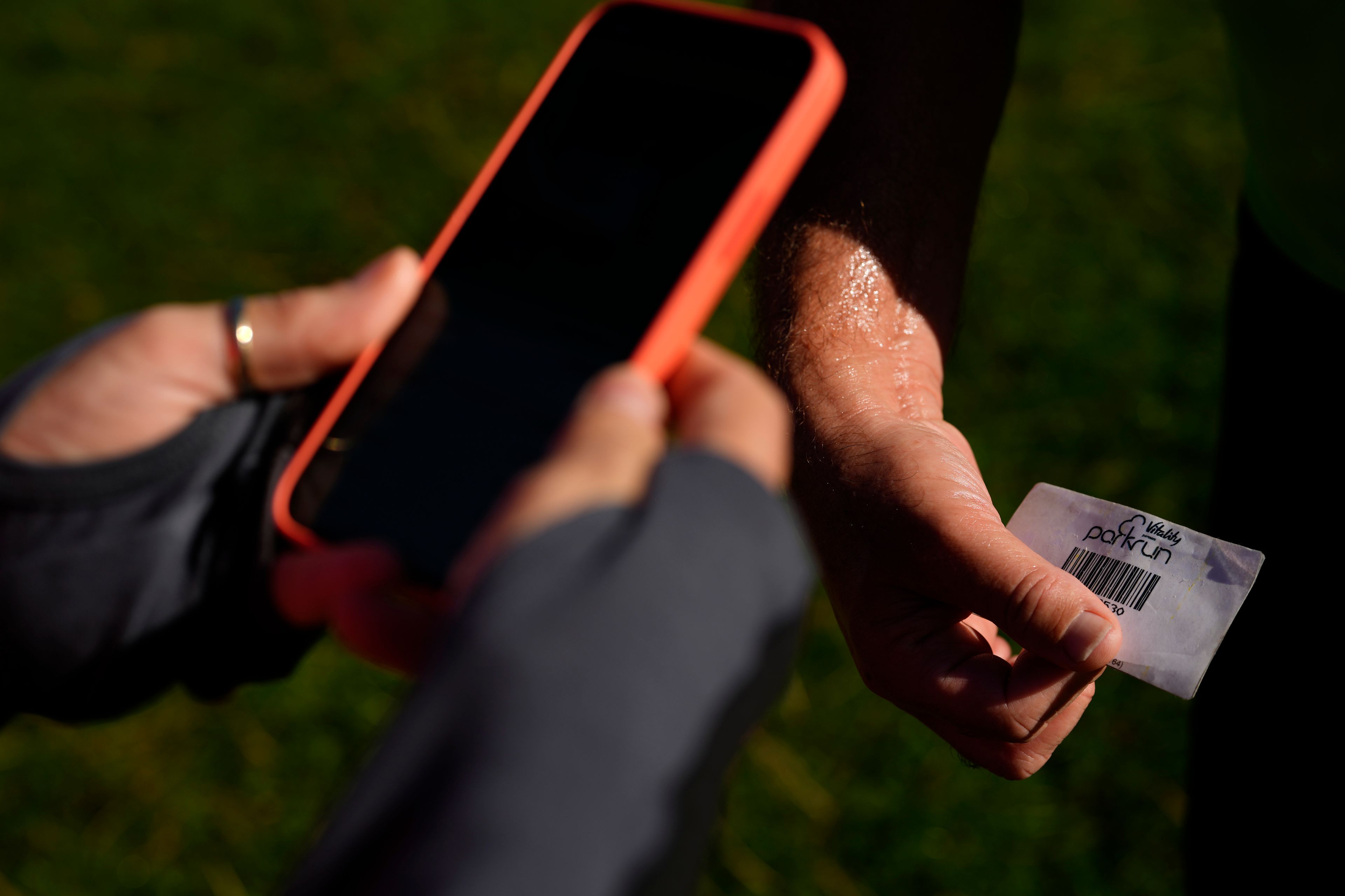 Competitors show a bar code after competing in the parkrun event in Bushy Park, southwest London, Saturday, Sept. 28, 2024. (AP Photo/Alastair Grant)