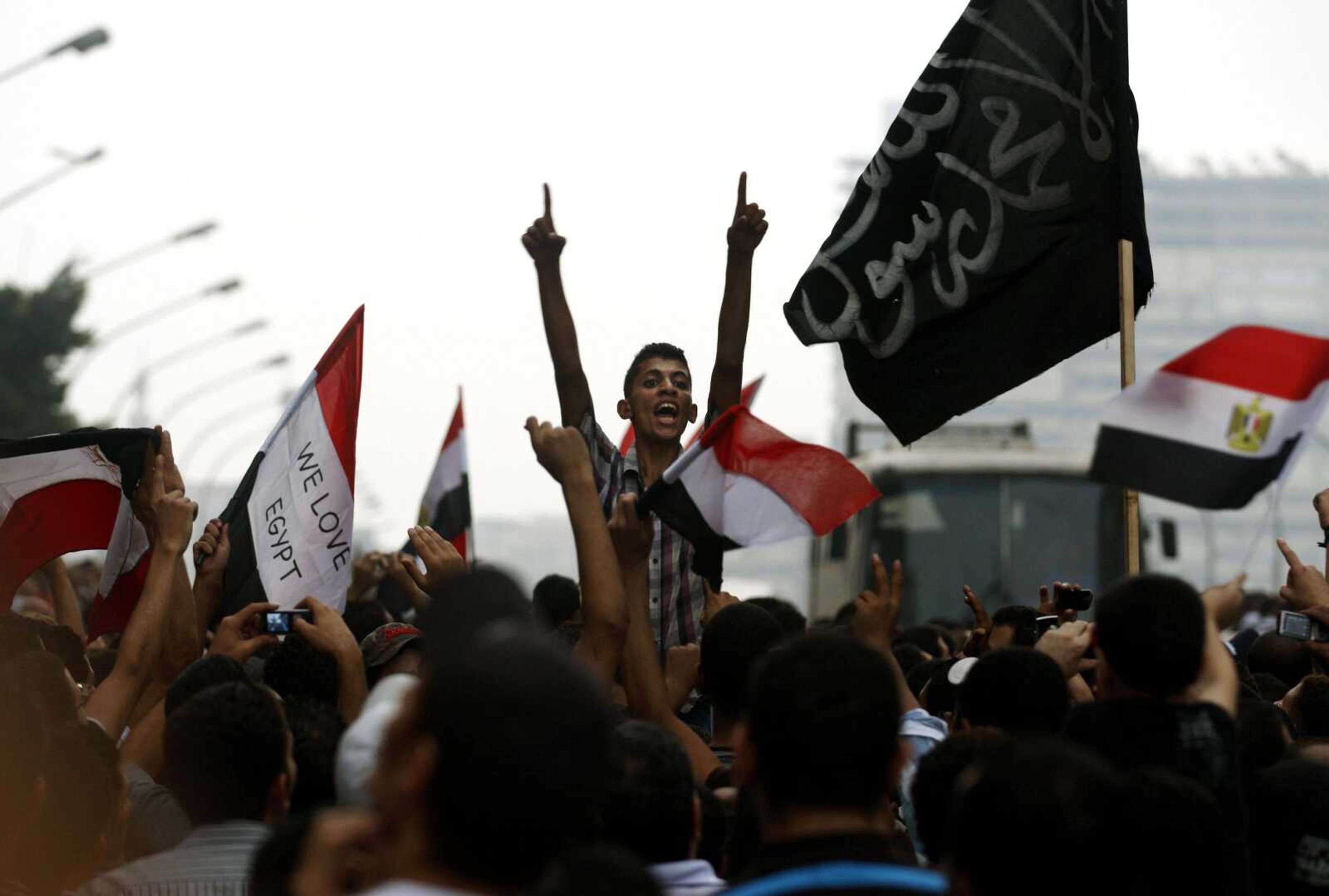 Egyptians chant anti-Israeli slogans Saturday in front of the Israeli embassy in Cairo as they hold Egyptian and Palestinian flags to protest the death of Egyptian security forces killed in a shootout between Israeli soldiers and Palestinian militants on Thursday in the Sinai. (Khalil Hamra ~ Associated Press)