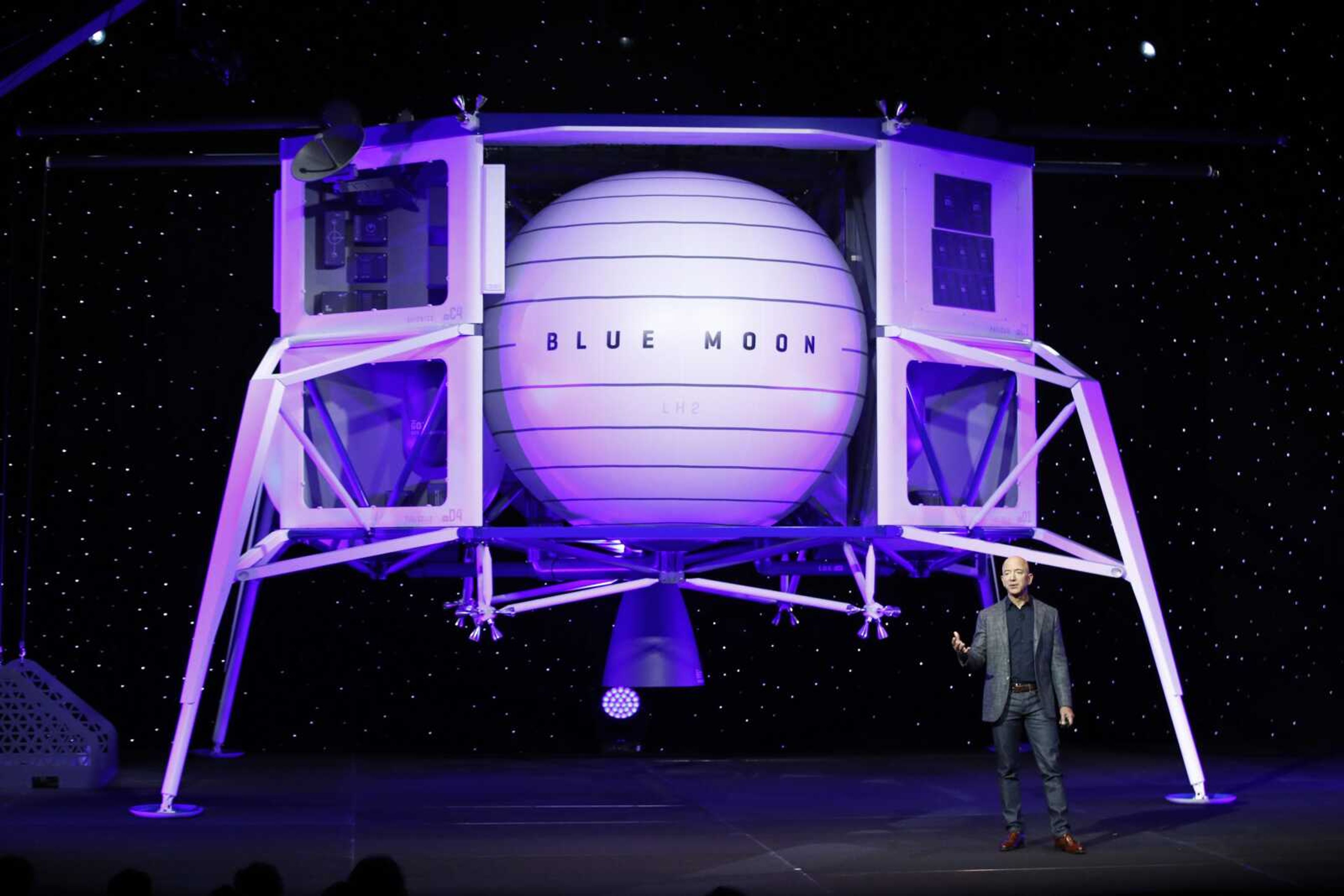 Jeff Bezos speaks in front of a model of Blue Origin's Blue Moon lunar lander May 9 in Washington. Bezos and Virgin Galactic's Richard Branson favor going back to the moon before Mars.<br>SpaceX's Elon Musk also is rooting for the moon, although his heart's on Mars.