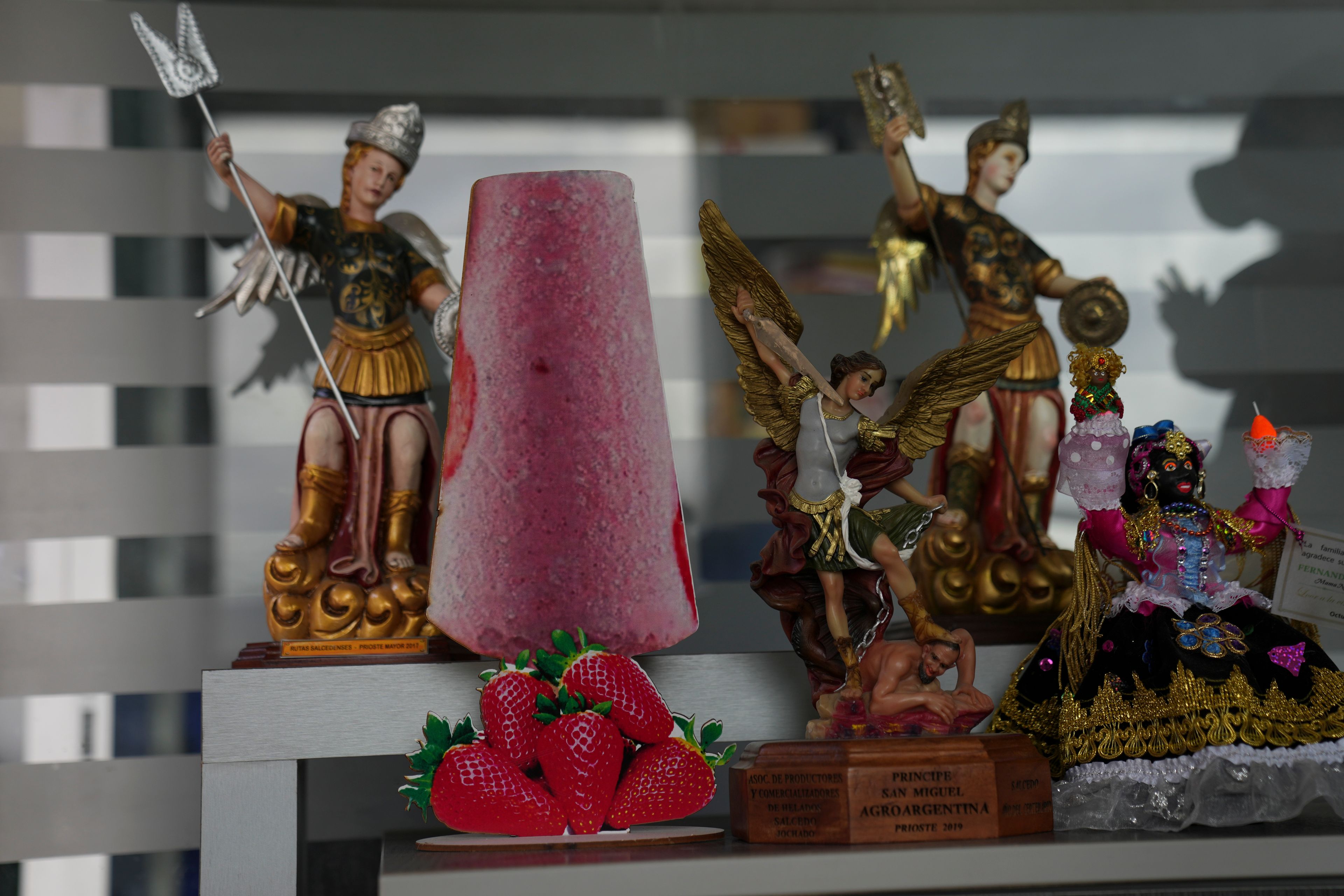 A cutout of a popsicle adorns a shelf next to a statue of patron saint Michael the Archangel in Salcedo, Ecuador, Thursday, Nov. 28, 2024, amid a wave of power outages, triggered by a prolonged dry spell. (AP Photo/Dolores Ochoa)