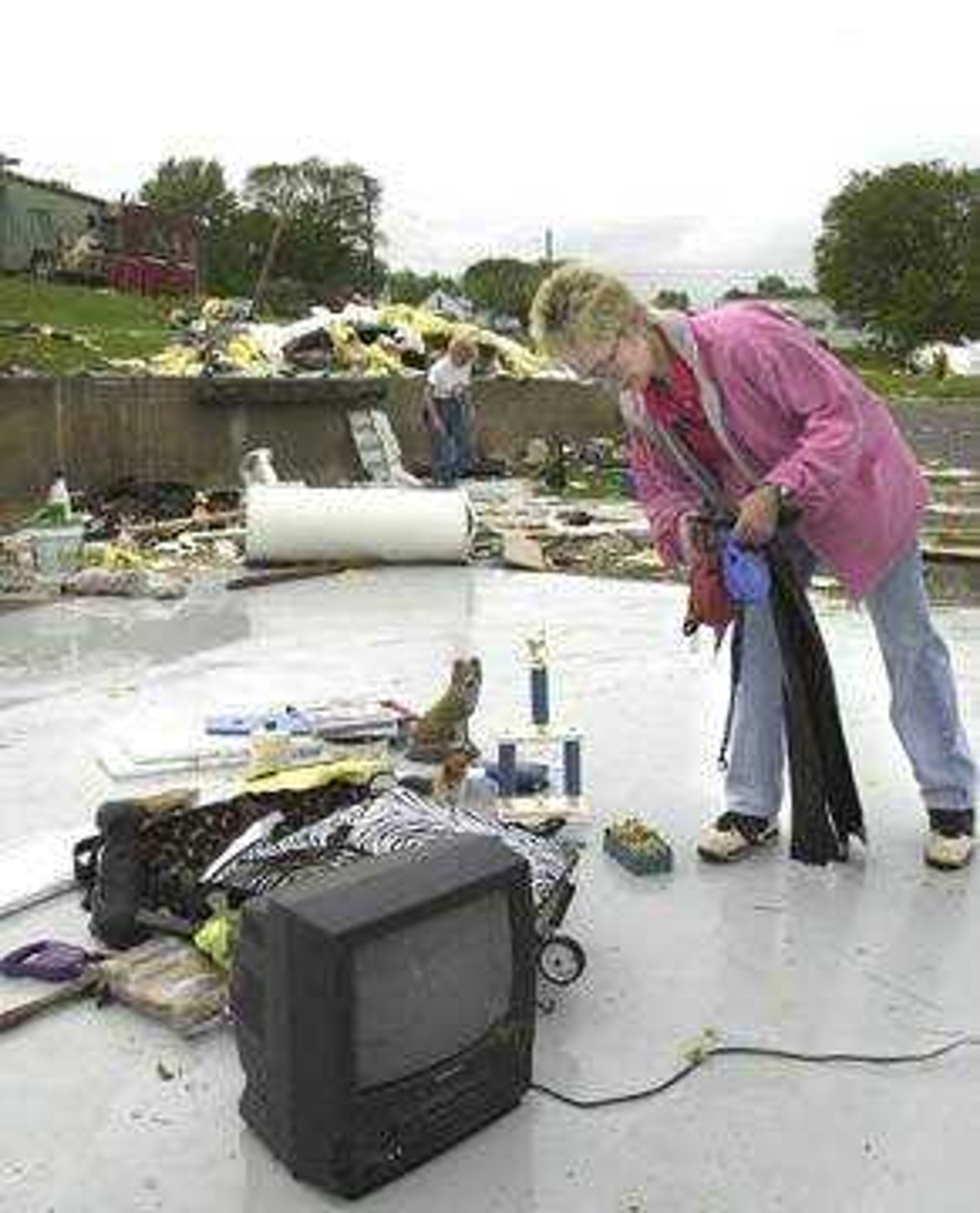 Mary Puls (right) and Bobby Mize (background) assisted in searching through what remained of the K-9 Training Center looking for property that was not damaged in Tuesday night's tornado in Jackson.