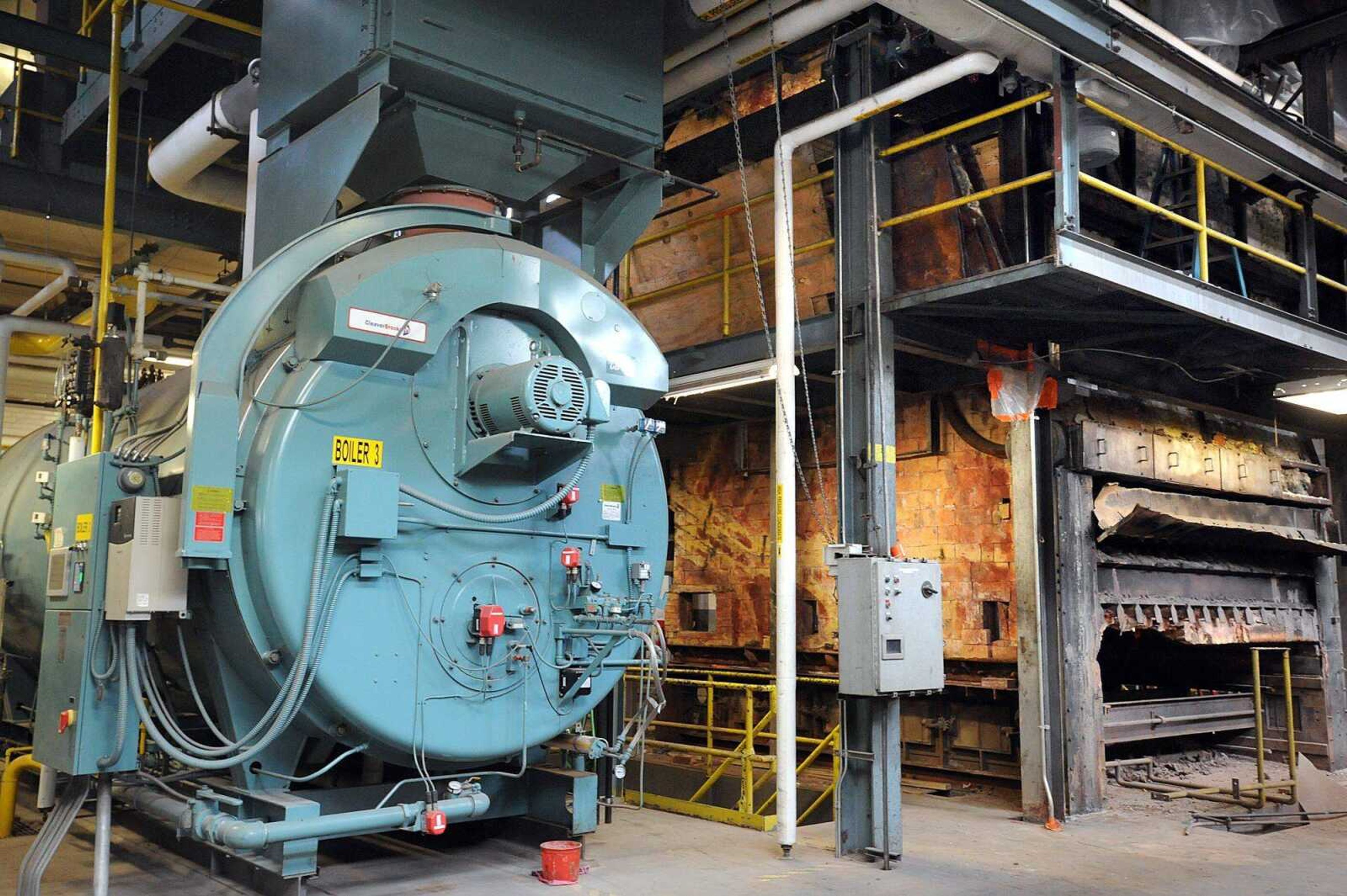 One of four gas-powered boilers, left, sits next to the old coal-powered boiler inside Southeast Missouri State University&#8217;s power plant. (Laura Simon)