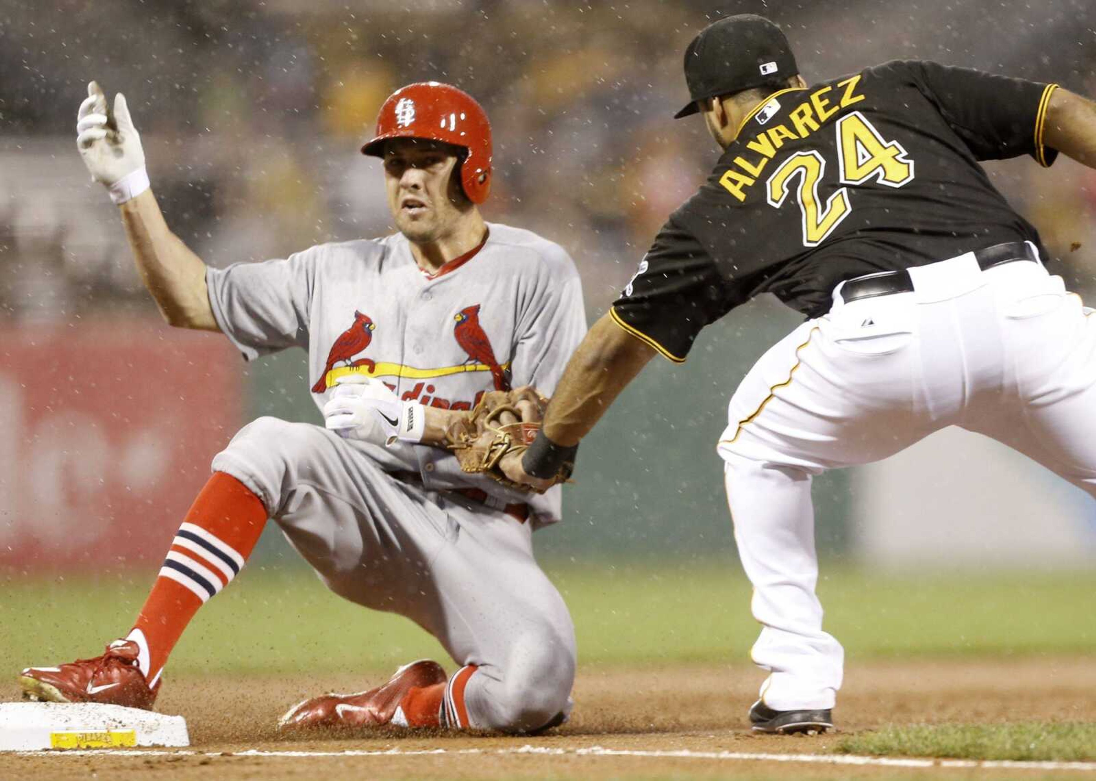 St. Louis Cardinals&#8217; Peter Bourjos, left, slides into third ahead of a tag by Pittsburgh Pirates third baseman Pedro Alvarez with a triple Friday in Pittsburgh. (Keith Srakocic ~ Associated Press)