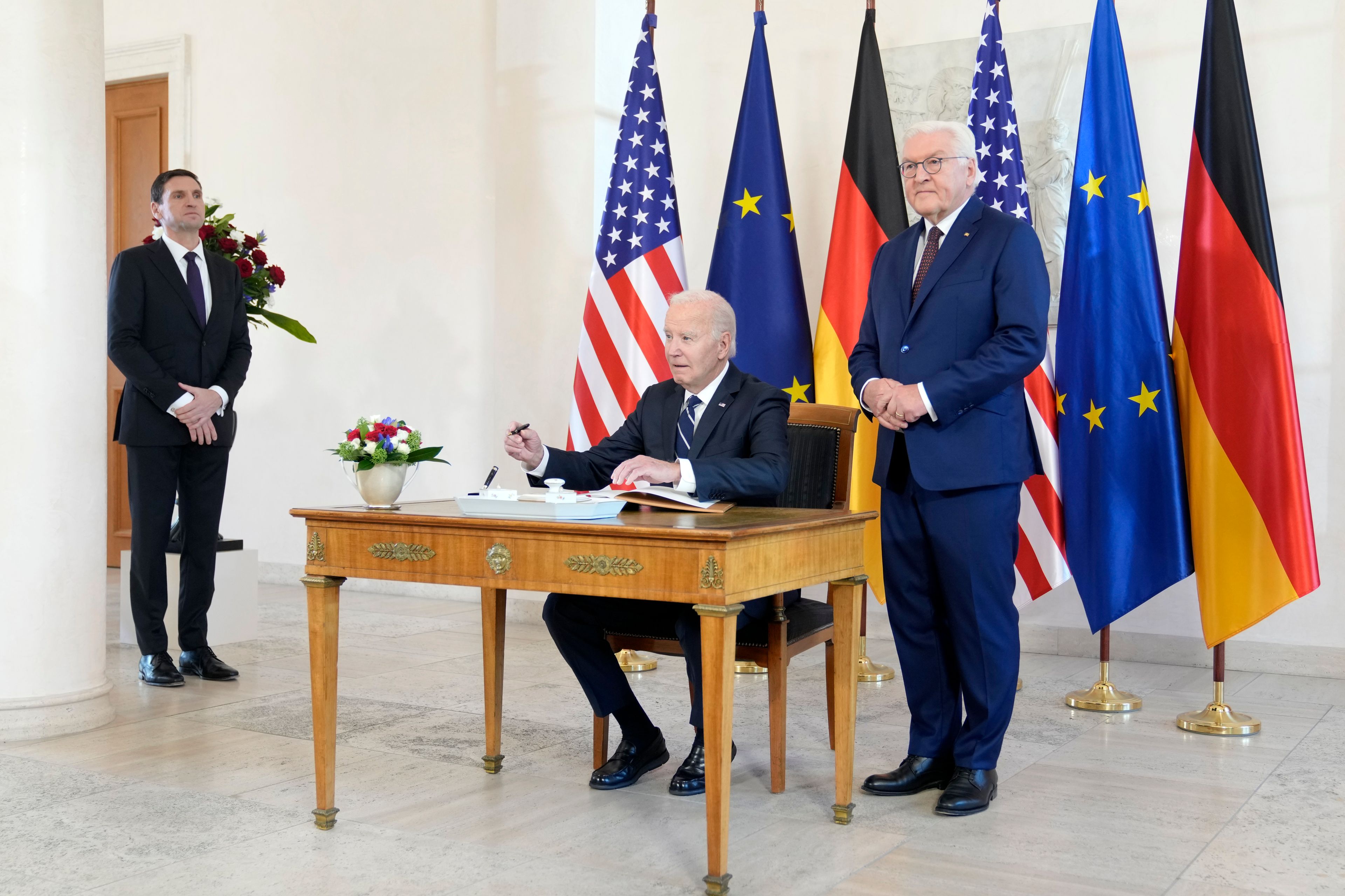 President Joe Biden signs a guest book beside German President Frank-Walter Steinmeier during the welcoming ceremony at Bellevue Palace in Berlin, Germany, Friday, Oct. 18, 2024. (AP Photo/Markus Schreiber)