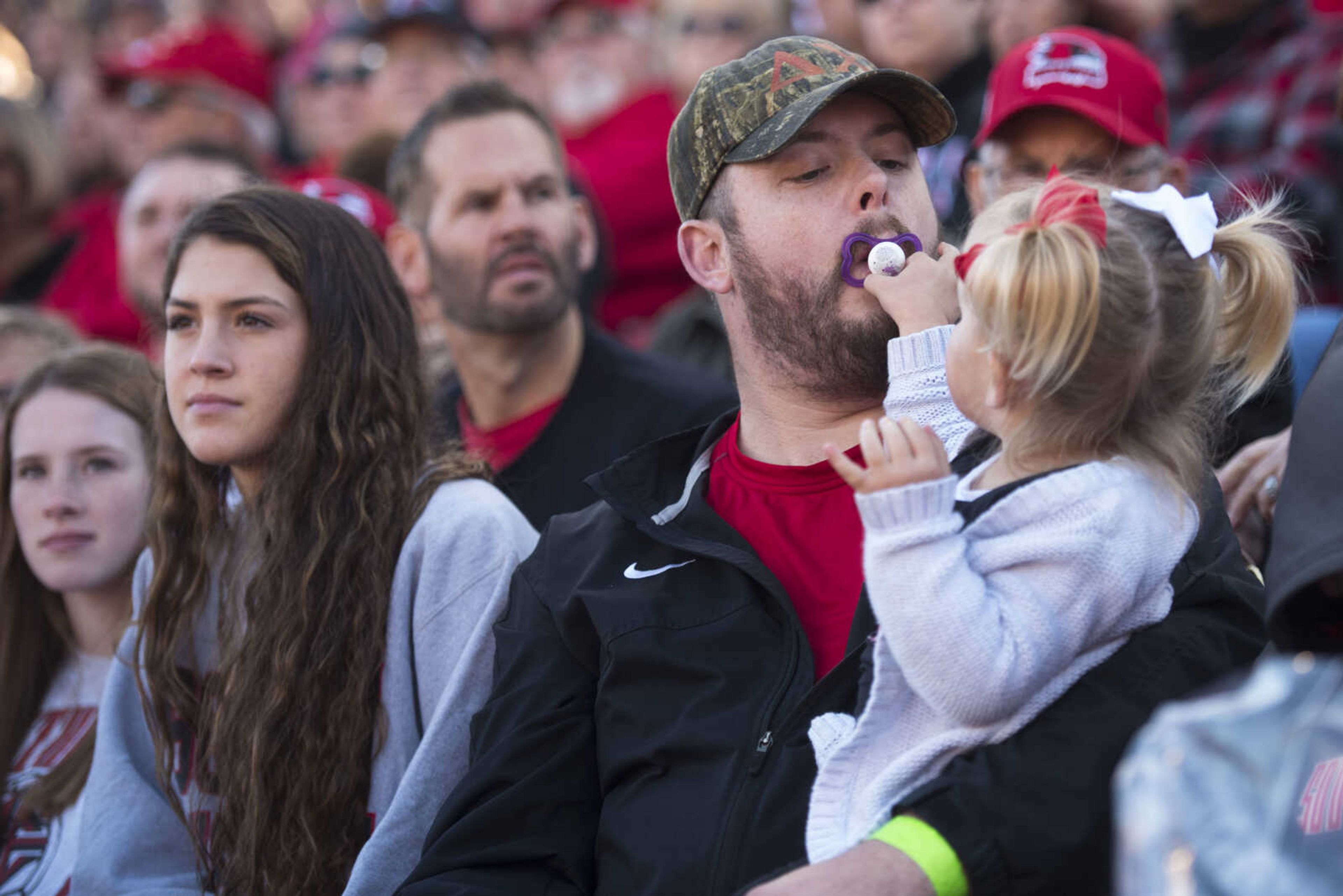 Ronnie Kate Michel reaches to retrieve her pacifier from Matt Schellingerhout's mouth during a Football Championship Subdivision playoff game between Southeast Missouri State and Stony Brook on Saturday, Nov. 24, 2018, at Houck Stadium in Cape Girardeau.