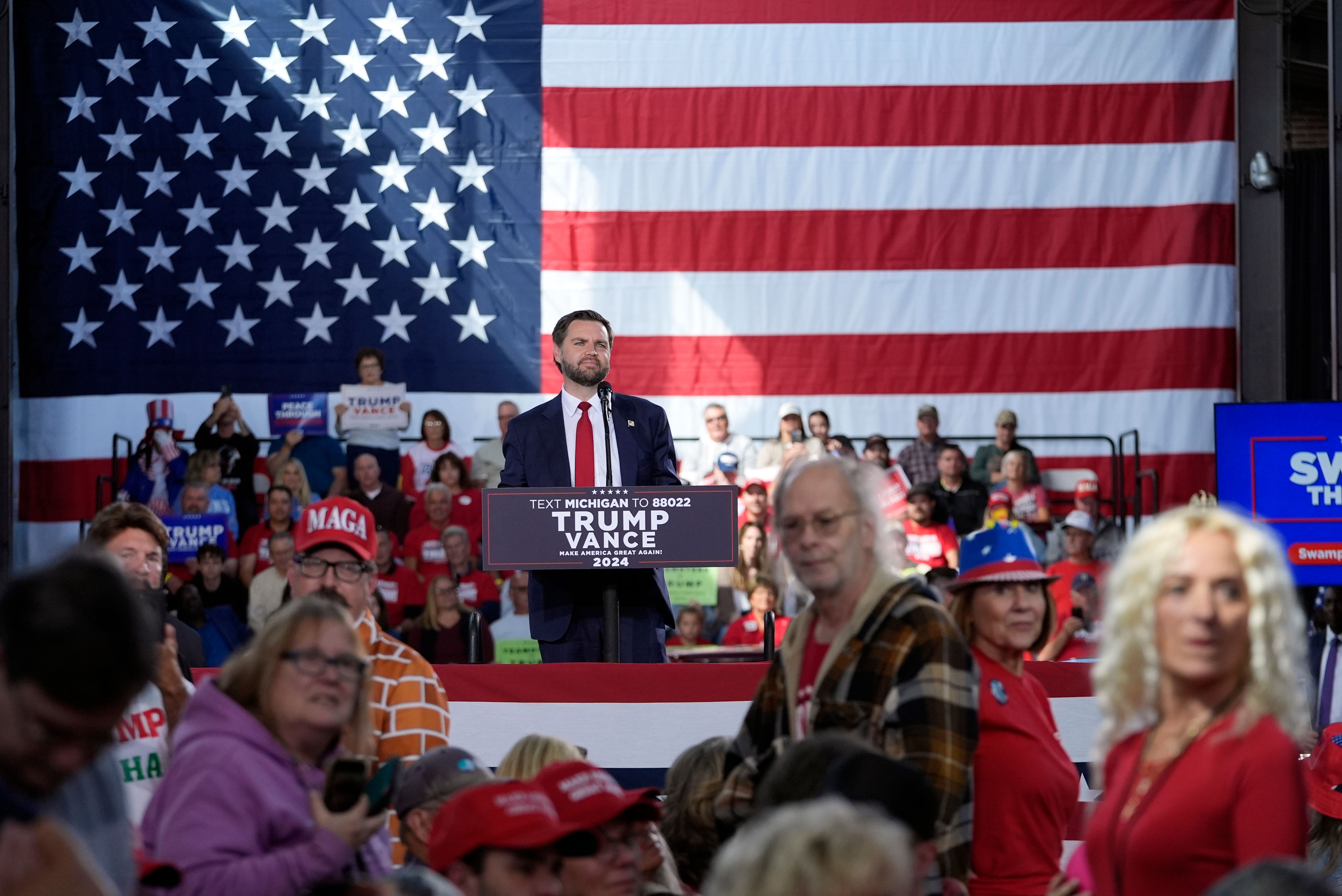 Republican vice presidential nominee Sen. JD Vance, R-Ohio, and supporters listens as reporters ask questions at a campaign event at Eastern Market Tuesday, Oct. 8, 2024, in Detroit. (AP Photo/Paul Sancya)