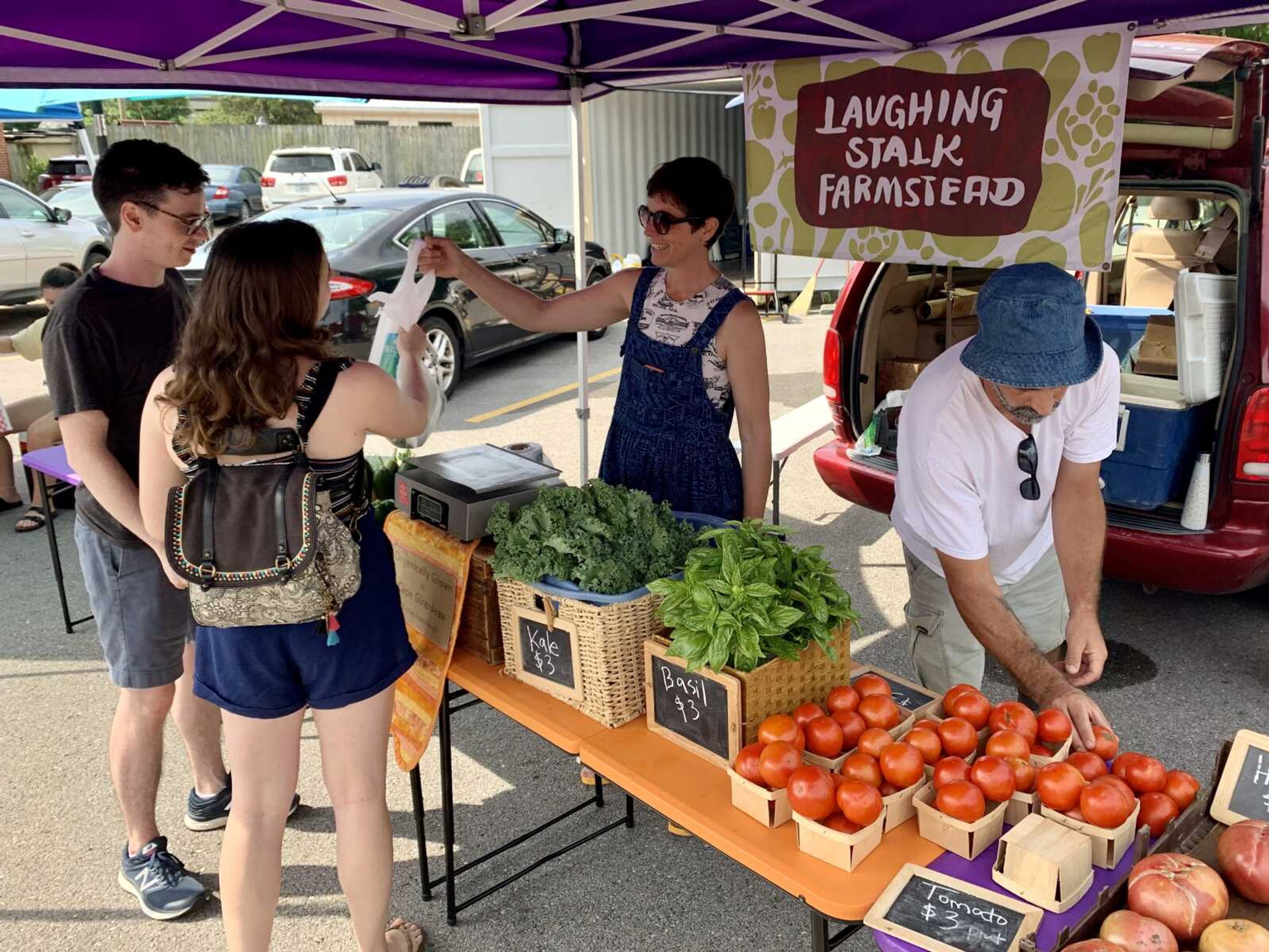 Owners of Laughing Stalk Farmstead, Emily Scifers and Ross Peterson, assist customers Saturday at Cape Riverfront Market in downtown Cape Girardeau.