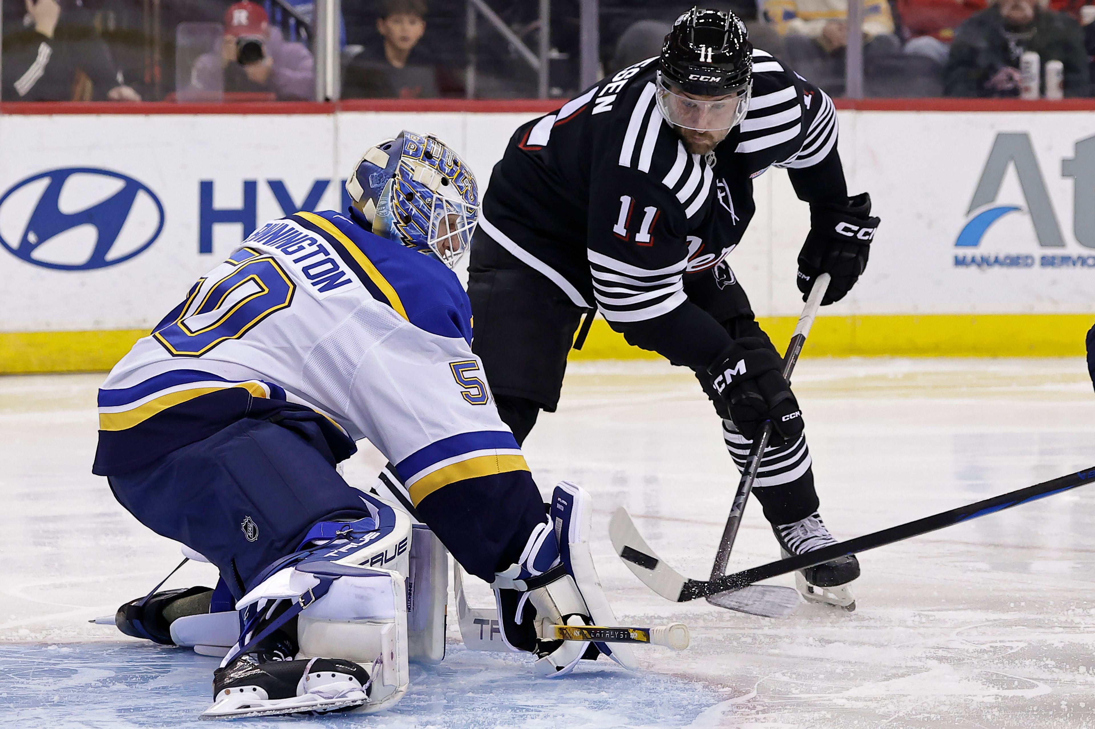 St. Louis Blues goaltender Jordan Binnington stops a shot in front of New Jersey Devils right wing Stefan Noesen (11) during the second period of an NHL hockey game, Wednesday, Nov. 27, 2024, in Newark, N.J. (AP Photo/Adam Hunger)