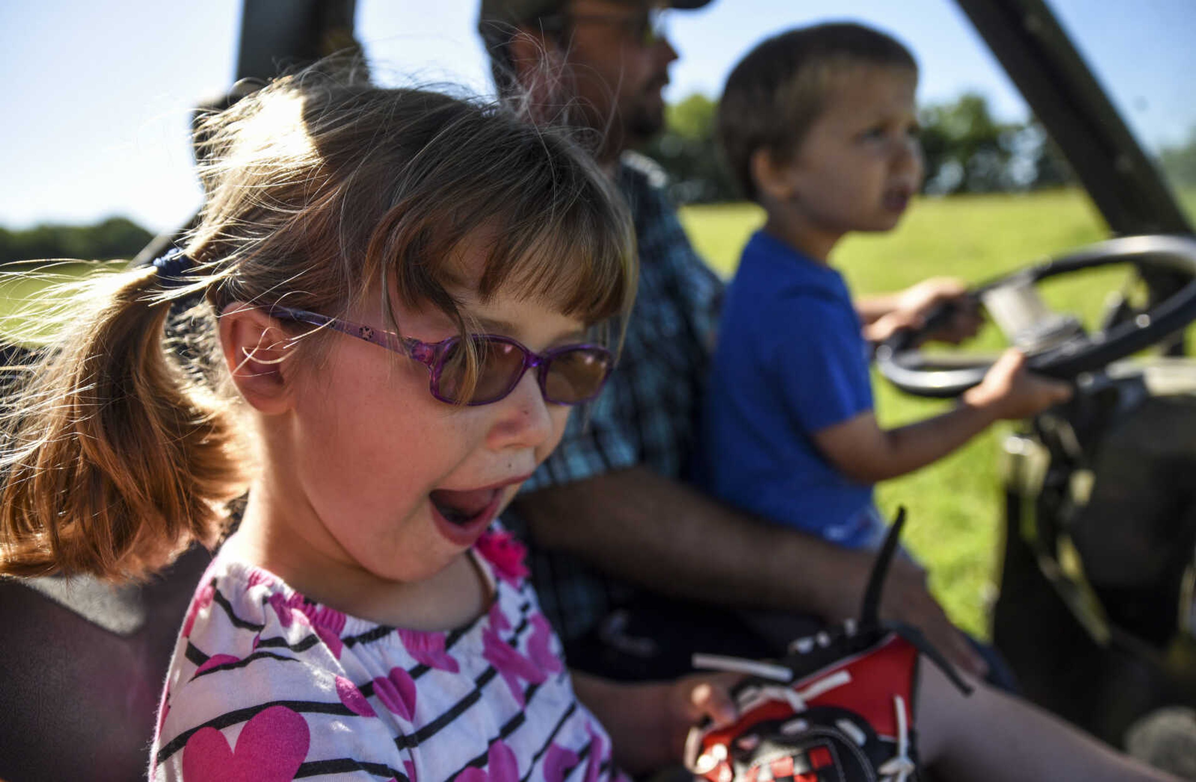 Lindyn Davenport, front, 6, rides in her family's ATV with her father William Davenport and little brother William Davenport, 3, while riding out to the pasture to feed their cows on their farm Sunday, June 3, 2018 in Sedgewickville.