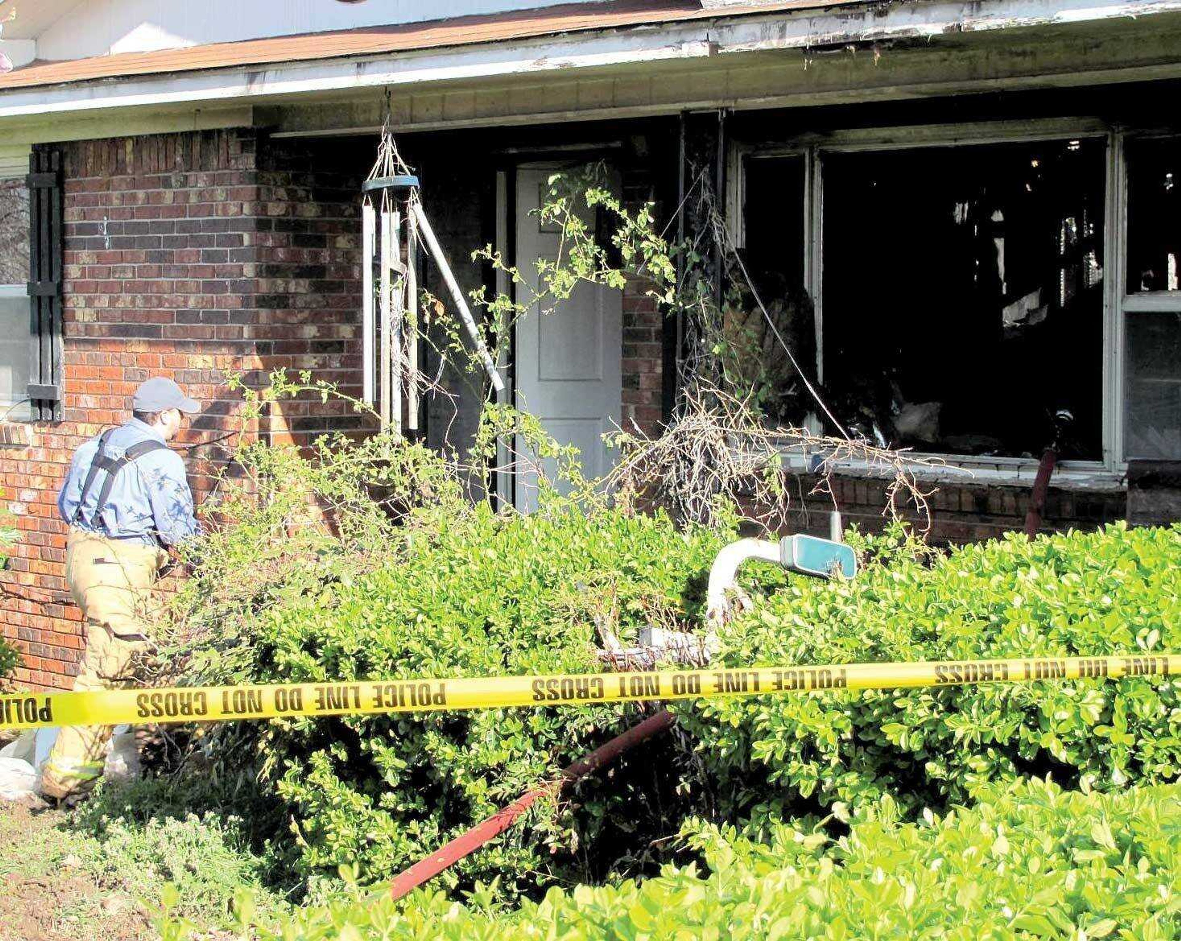 Jason Ward, an investigator with the New Madrid County Sheriff's Department, surveys the scene of a house fire at 376 W. State Highway U in New Madrid. Two men died in the blaze, which was reported just after 6 a.m. Tuesday. (Michelle Felter/Standard Democrat)