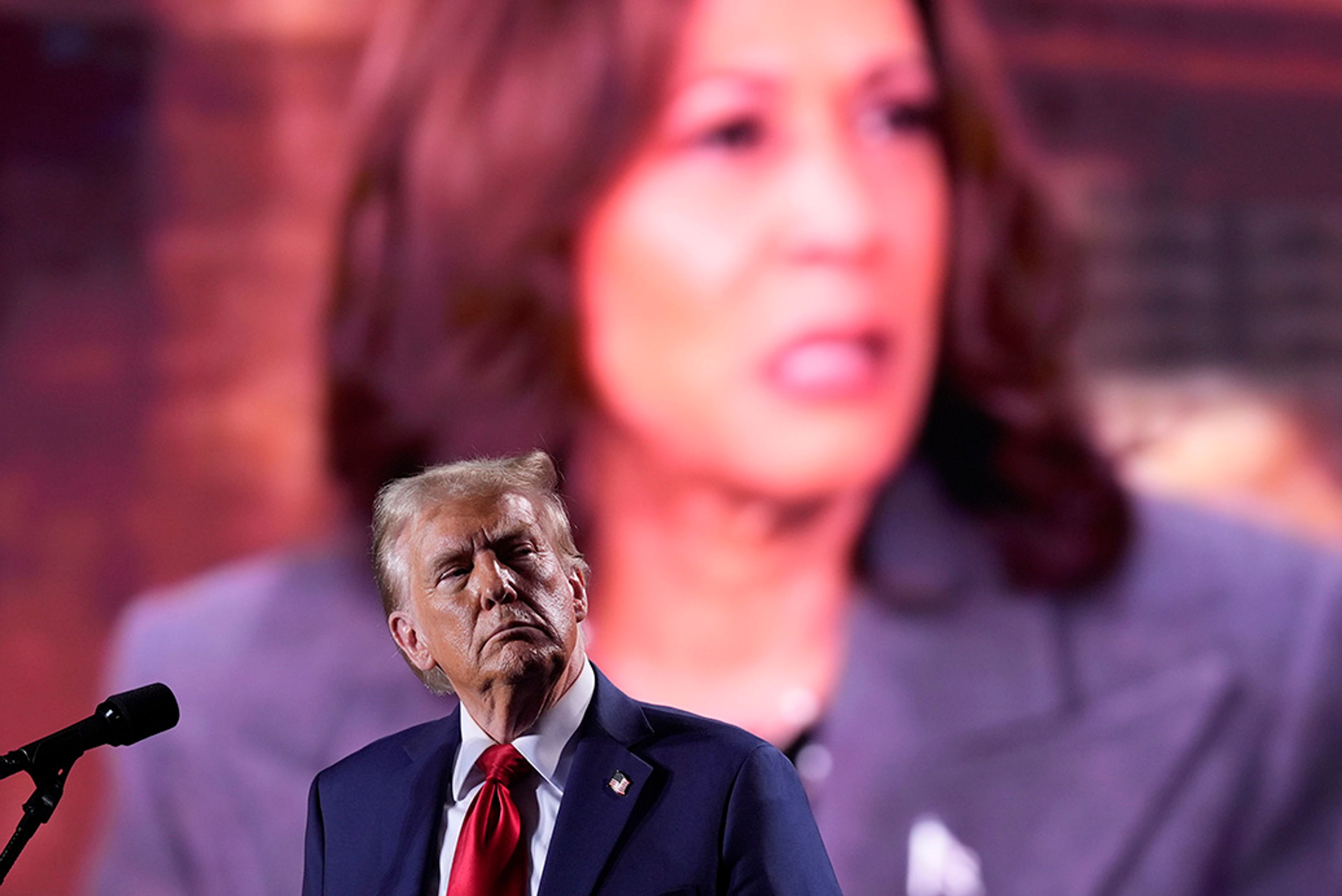 Republican presidential nominee former President Donald Trump watches as a video featuring Democratic presidential nominee Vice President Kamala Harris plays during a campaign event, Friday, Oct. 18, 2024 in Detroit.